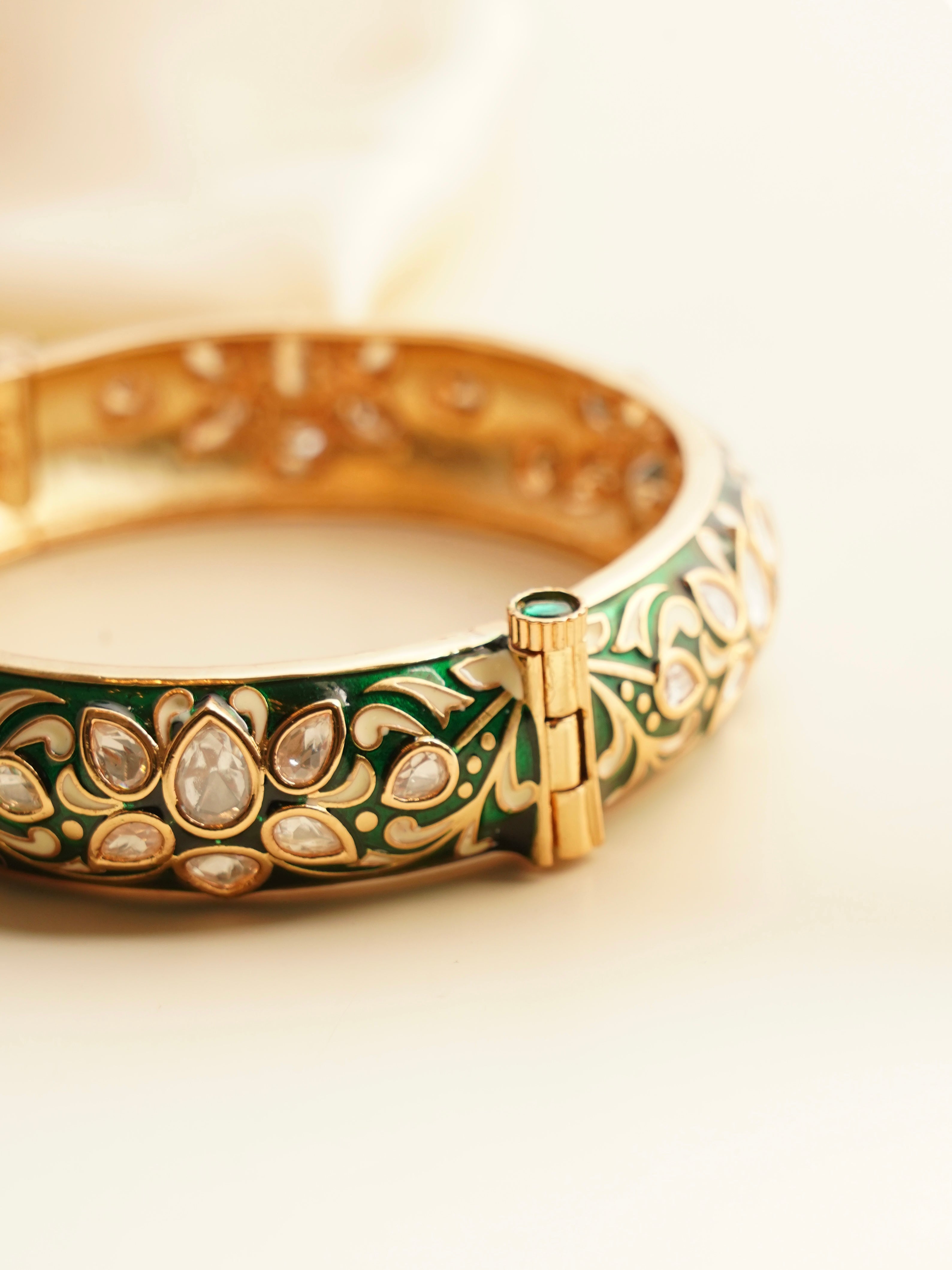 Angled image of meenakari kada with intricate polki embellishments