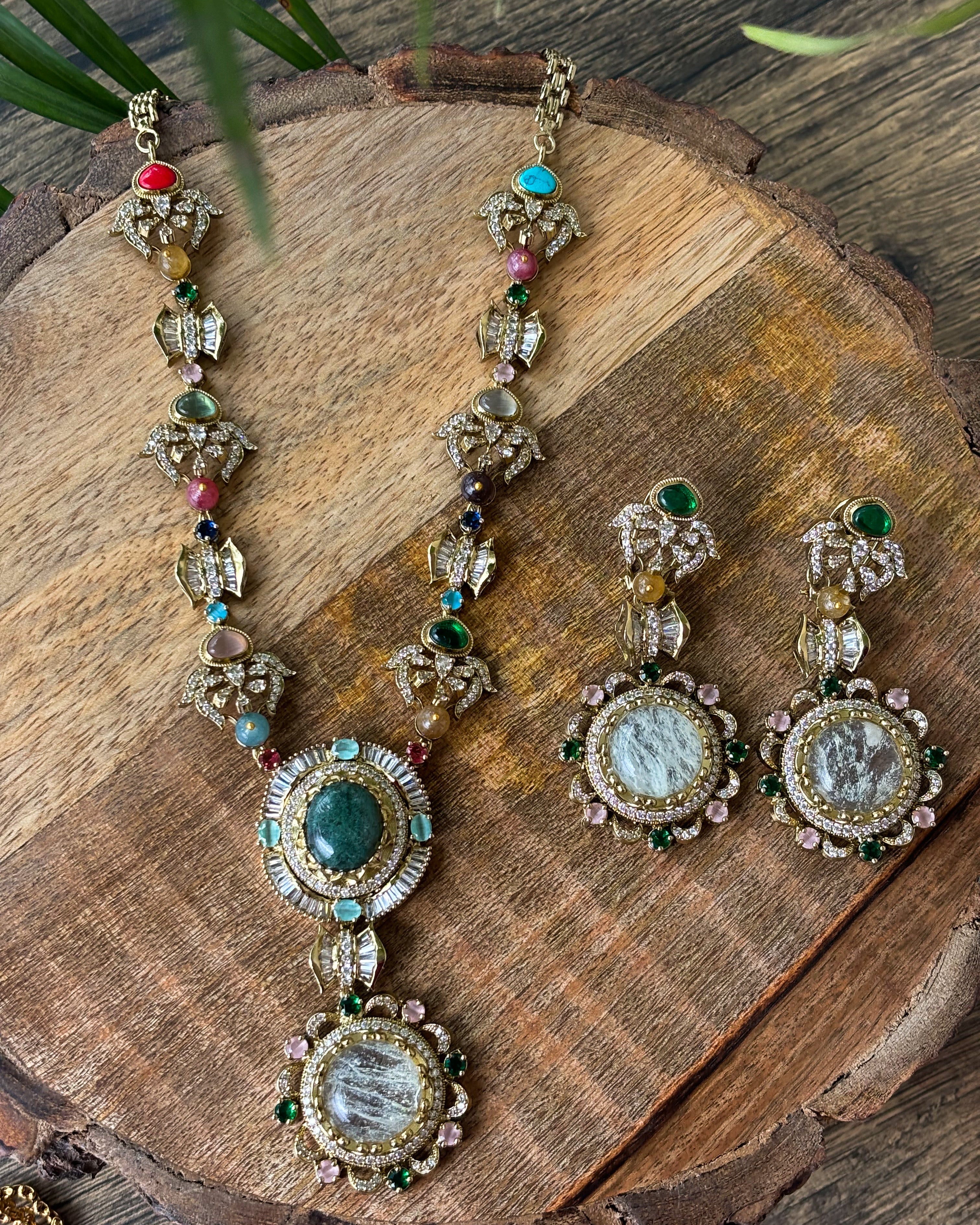 Side view of gemstone medallion necklace with coordinated earring pair