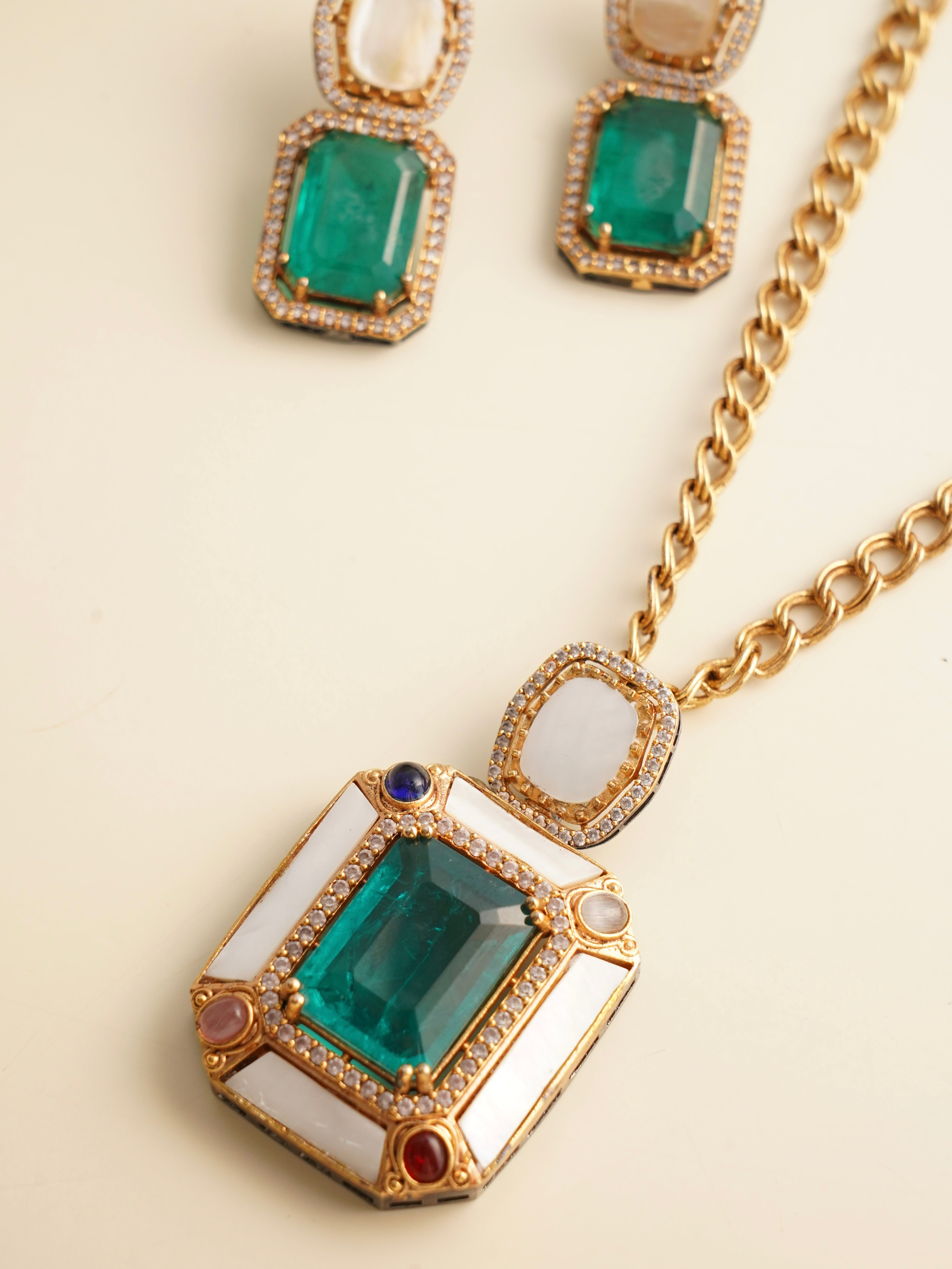 Emerald pendant set with pearl accents and multicolor stones, front facing view