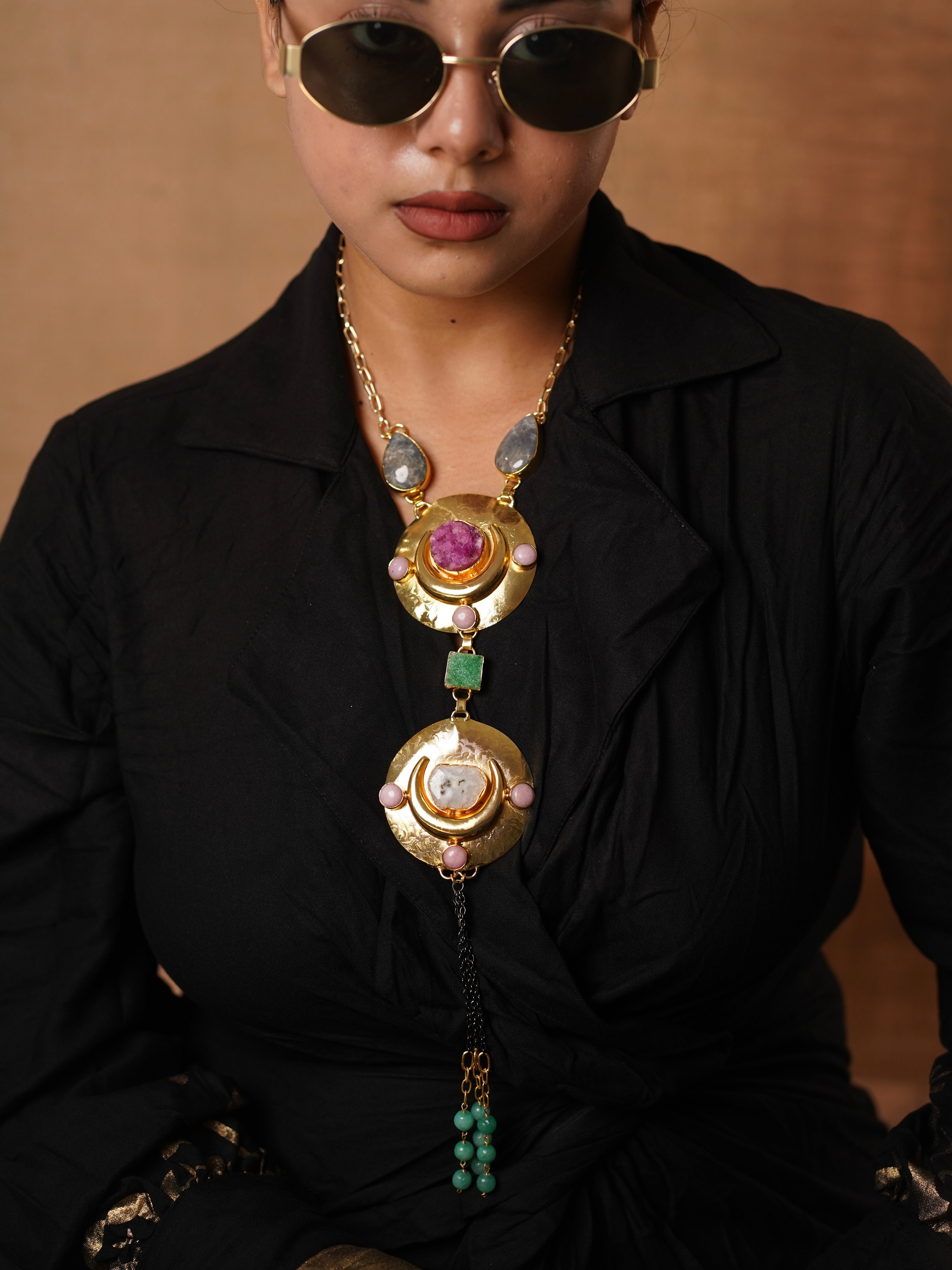 Zoomed-in view of statement necklace showing bold gem clusters and textured antique gold elements