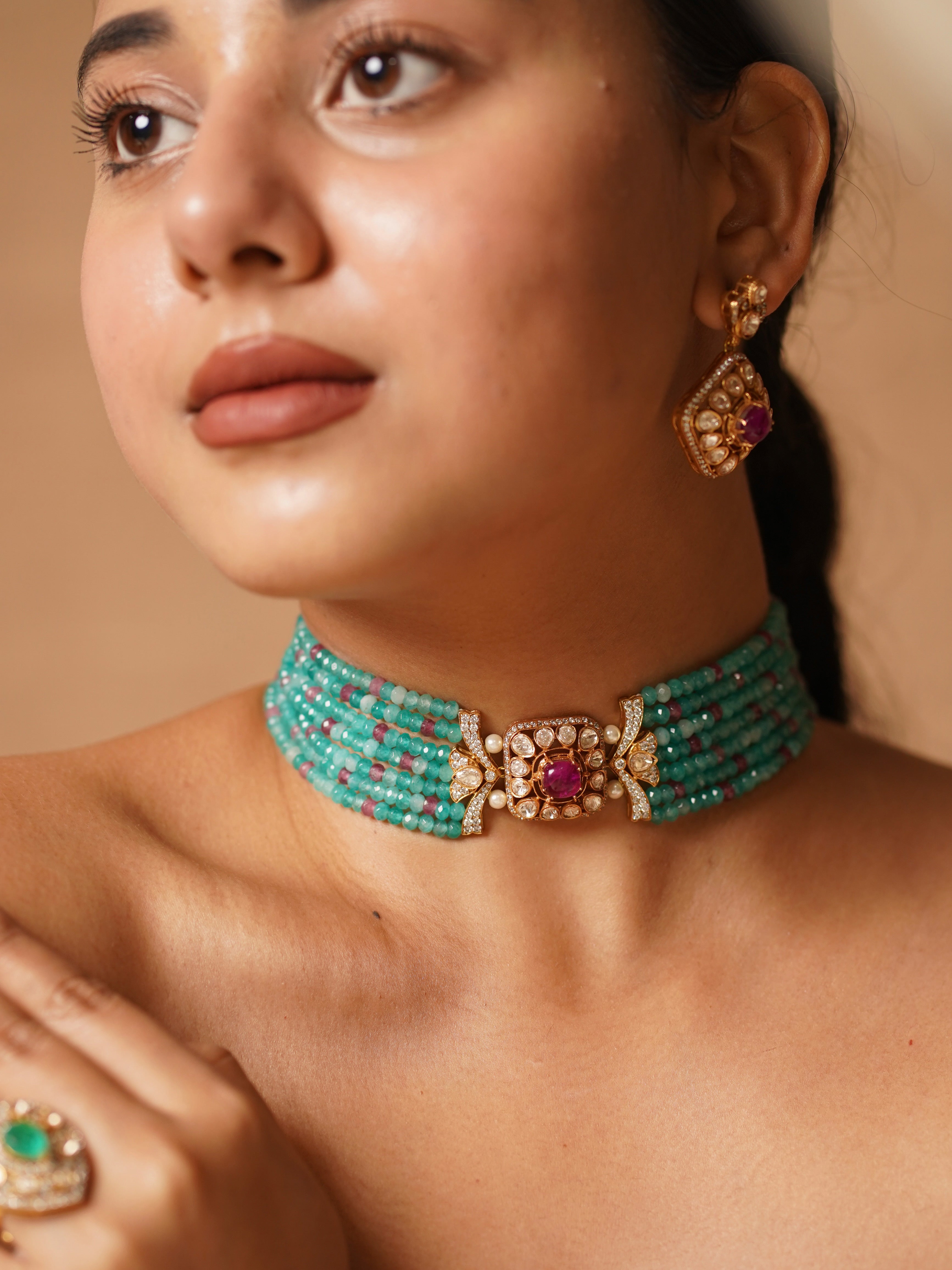 Emerald kundan choker set with gold detailing and drop-shaped green stones