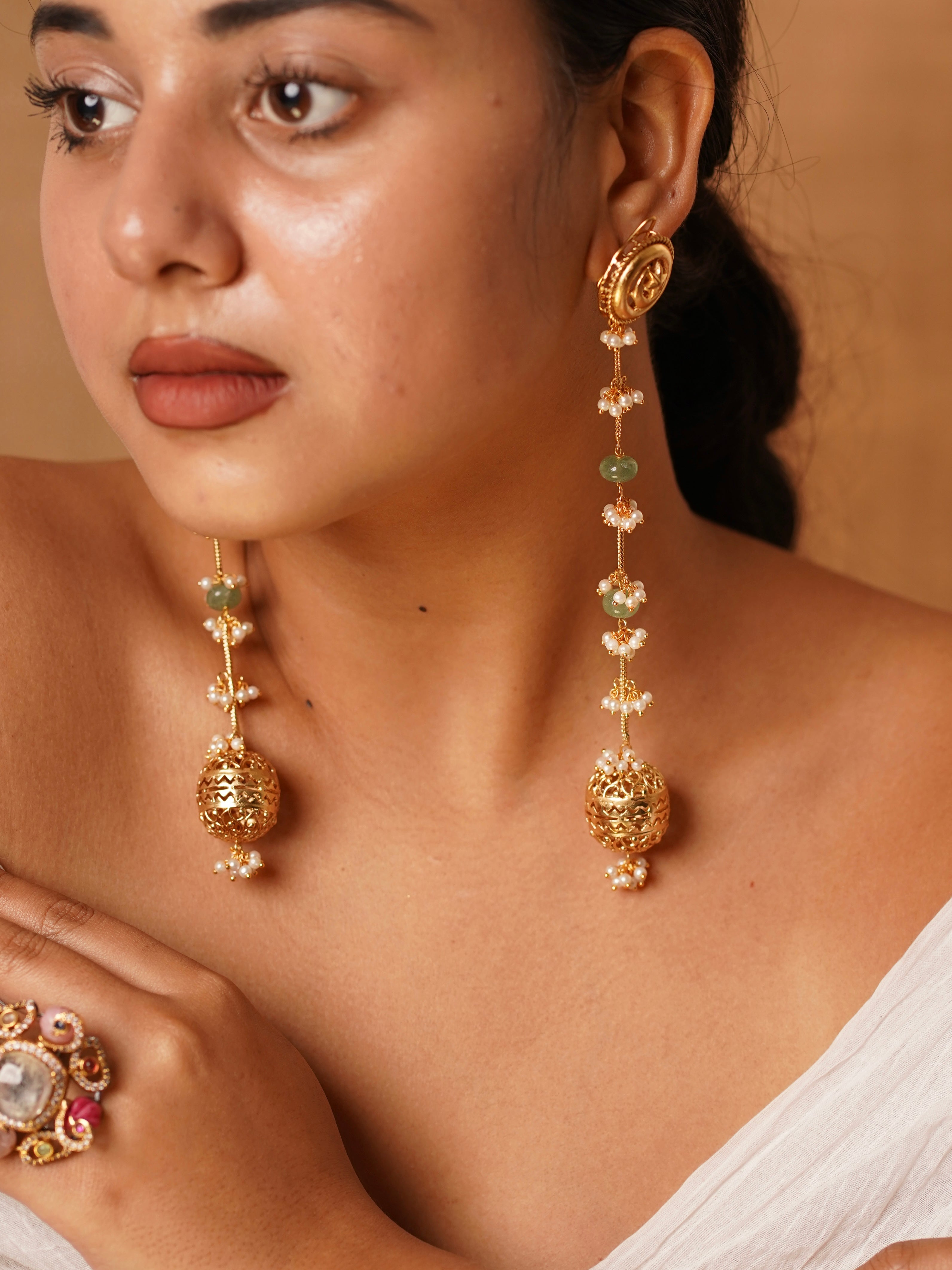 Temple-inspired drop earrings with carved jhumkas, pearl clusters and green gemstone accents