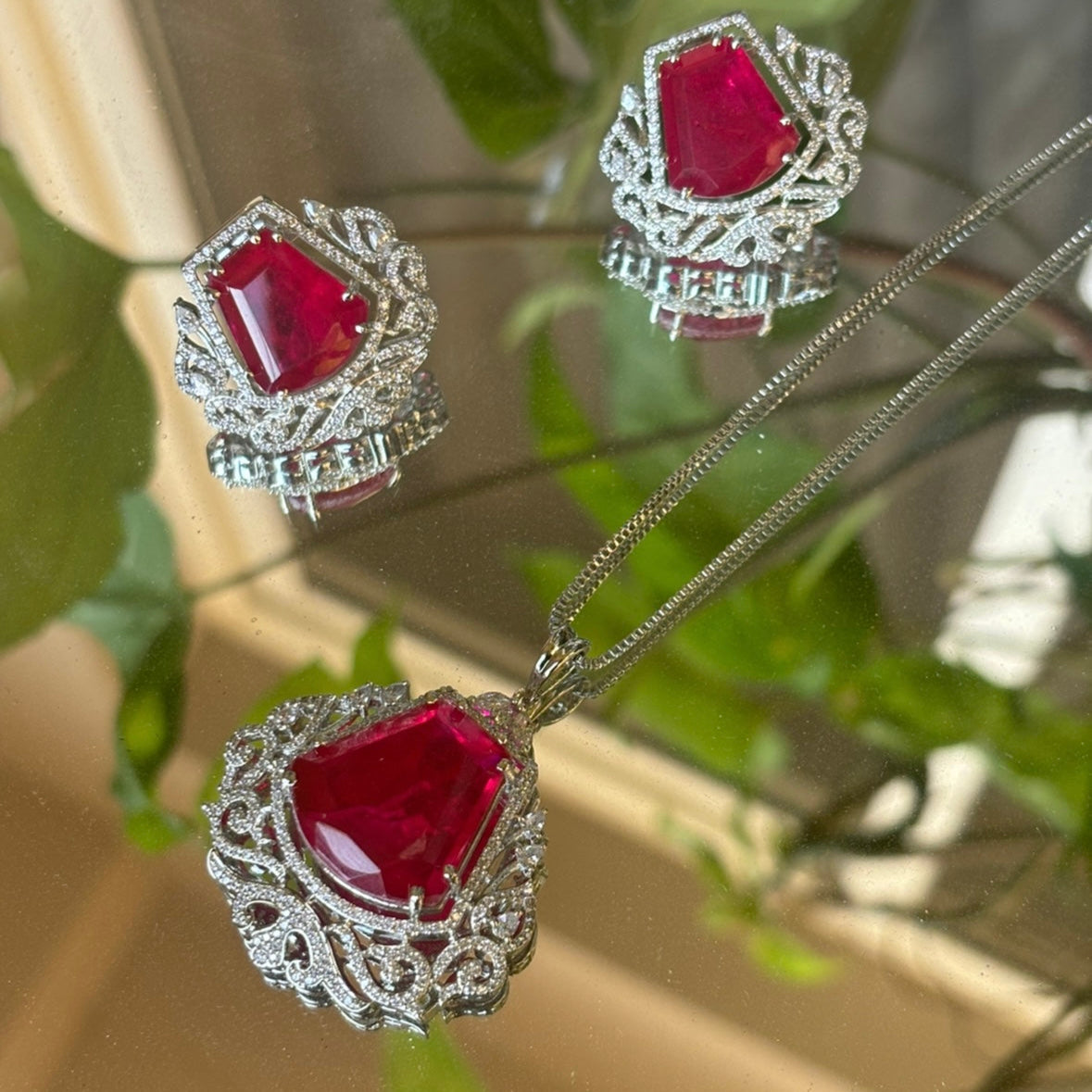 side view of ruby zircona pendant set with glossy gold tone and detailed stonework