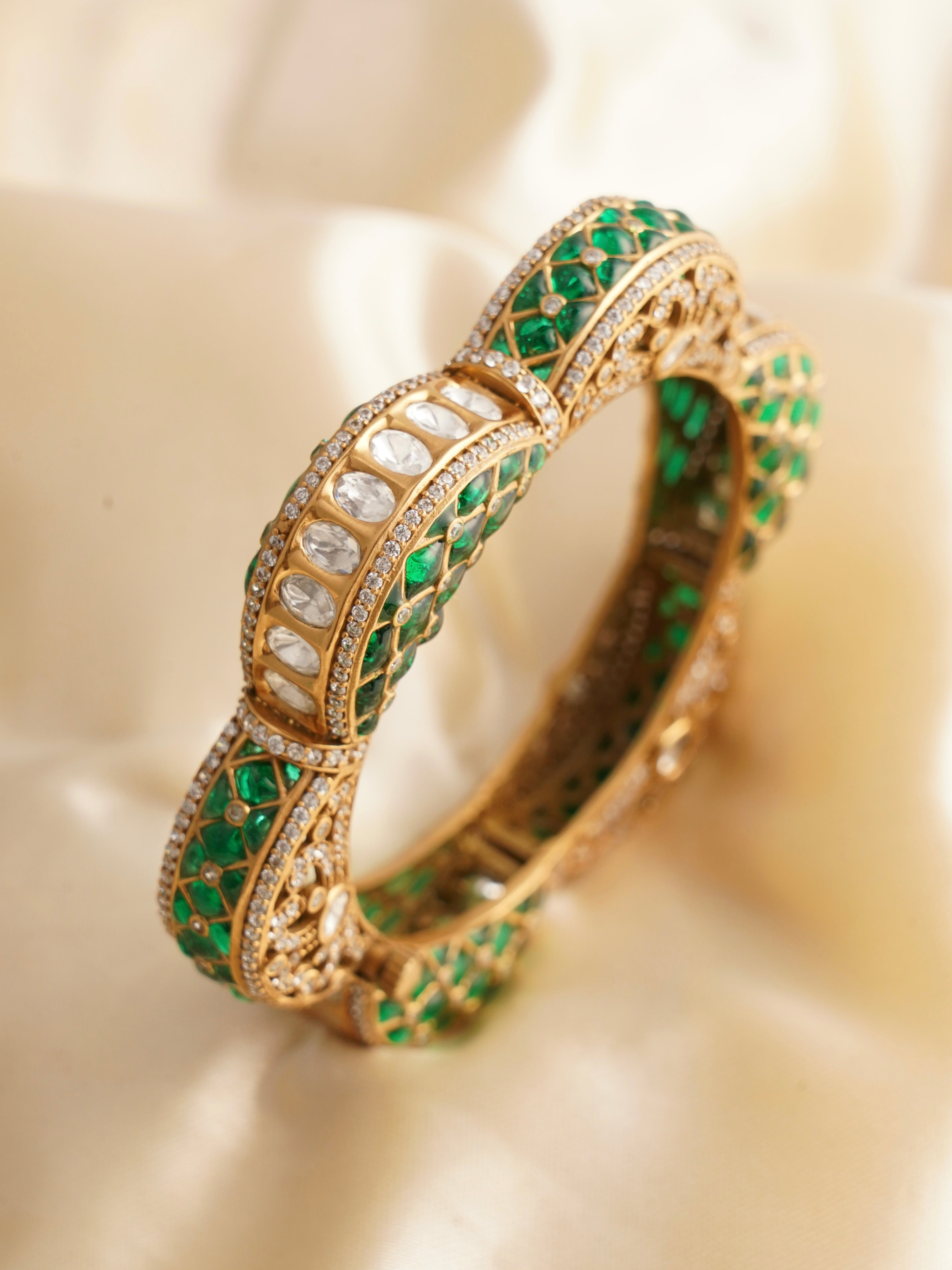 Openable kada bangle with alternating emerald and ruby inlays and kundan detailing