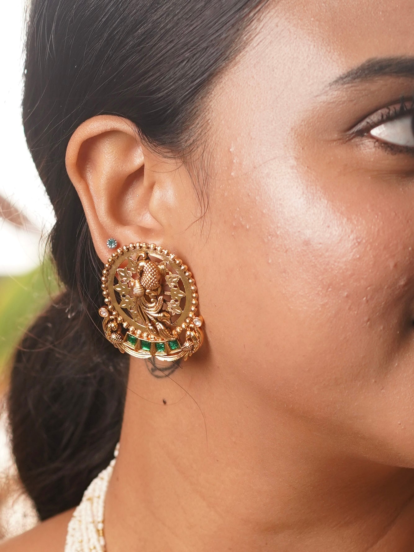 Side profile of pearl necklace featuring intricate carvings and antique gold detailing