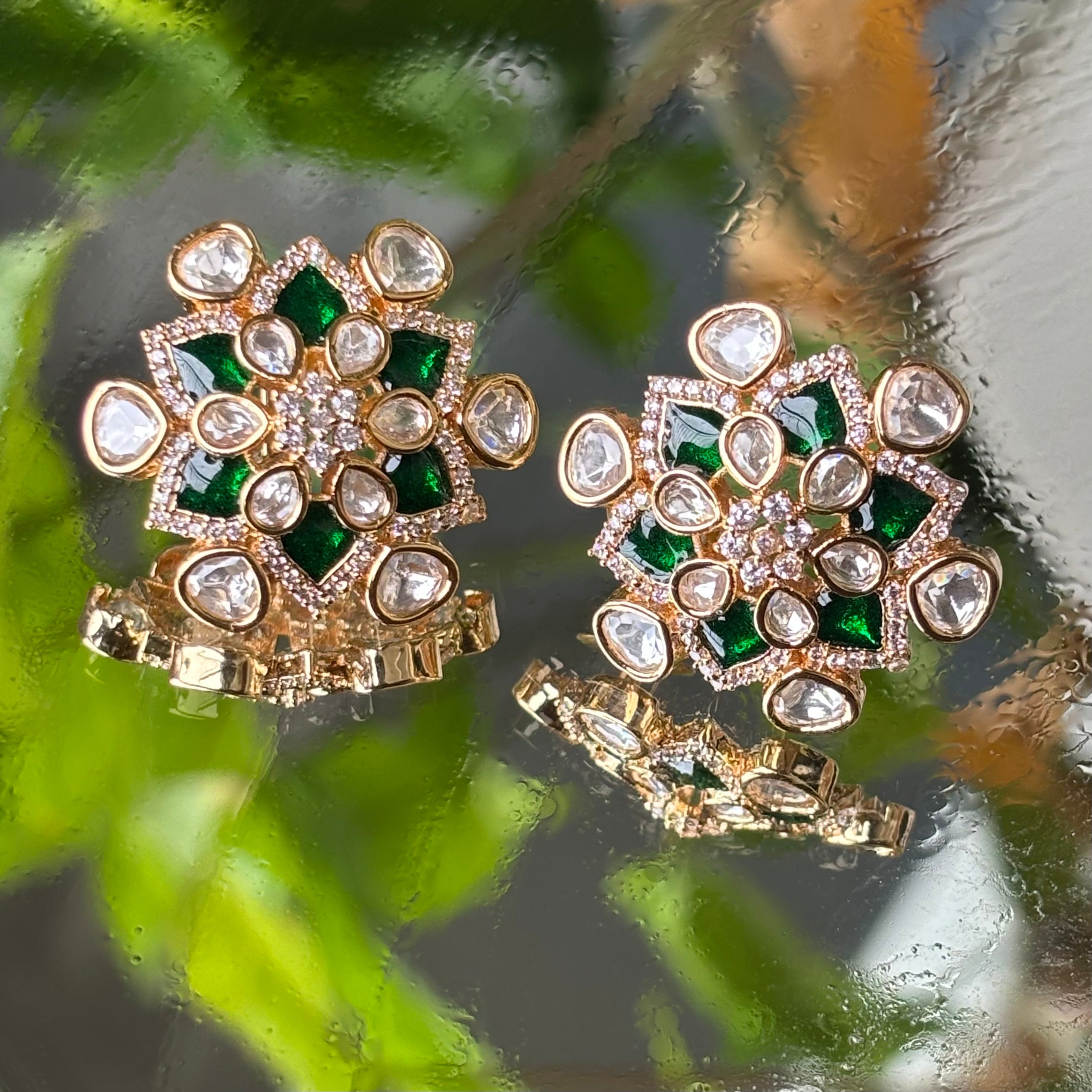 Side view of green enamel lotus studs with polished polki stone border