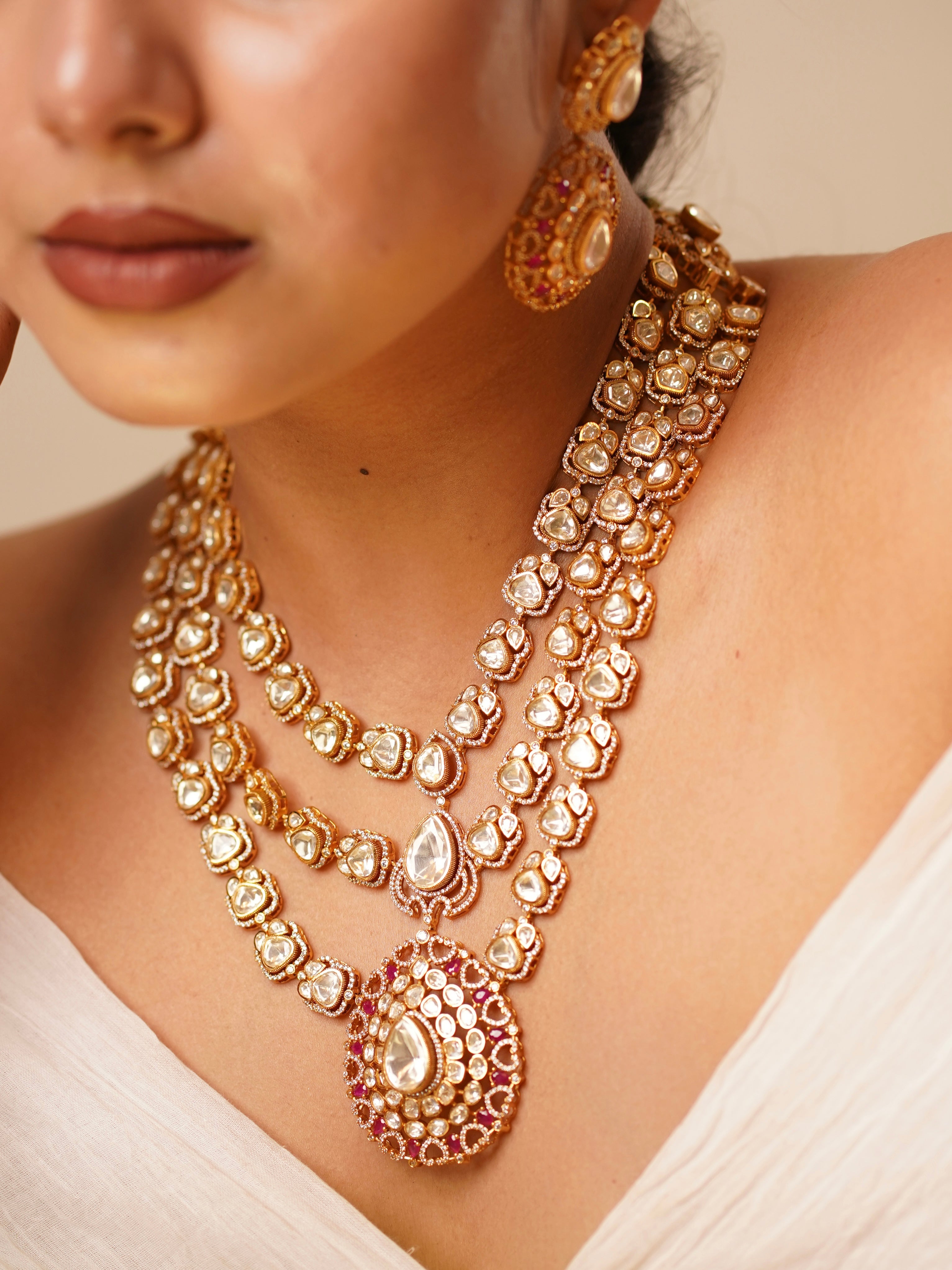 Layered moissanite bridal necklace set with ruby accents and antique finish, shown in frontal view