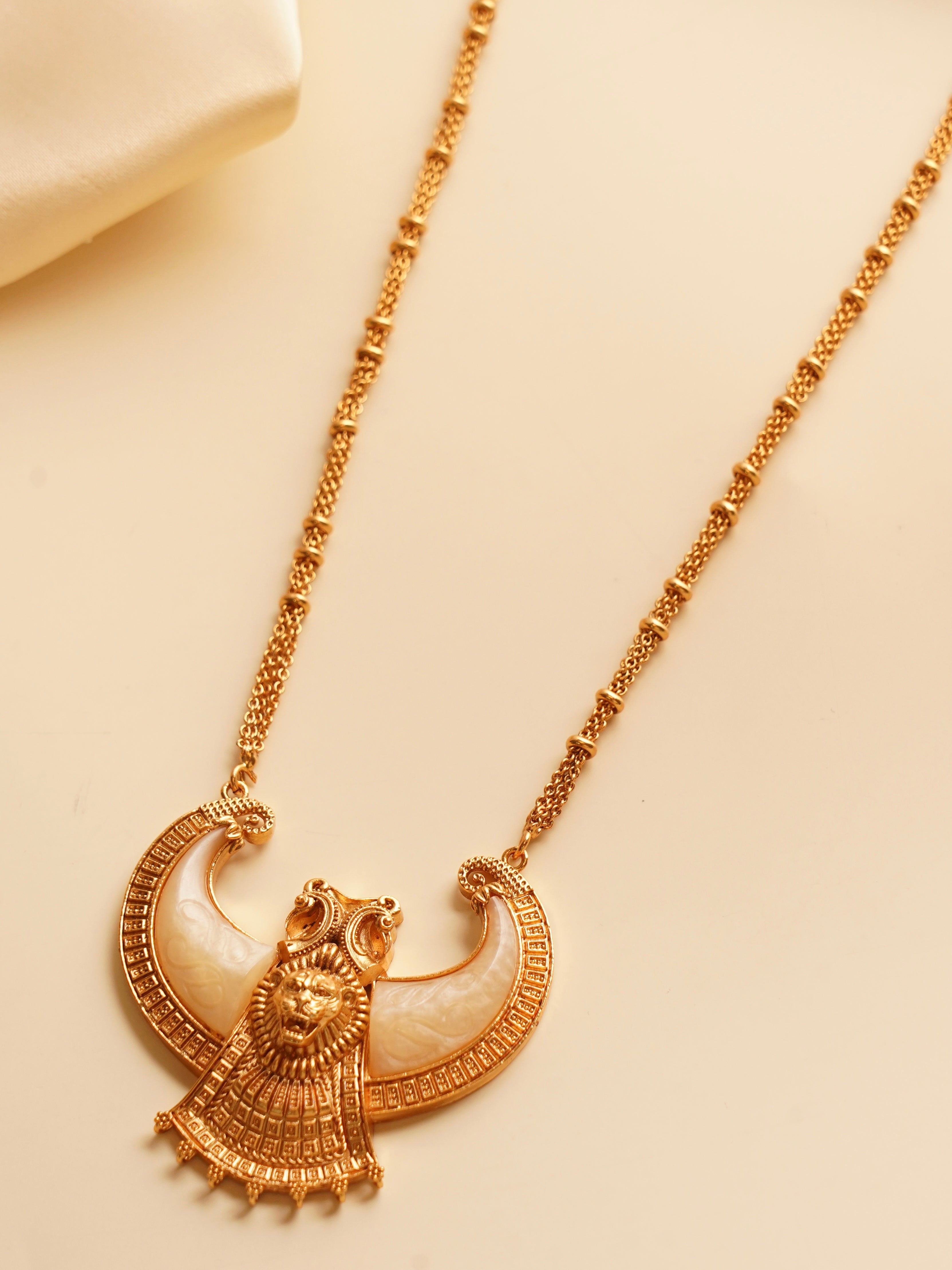 Close-up of lion-themed statement necklace with detailed gold work and bold centerpiece