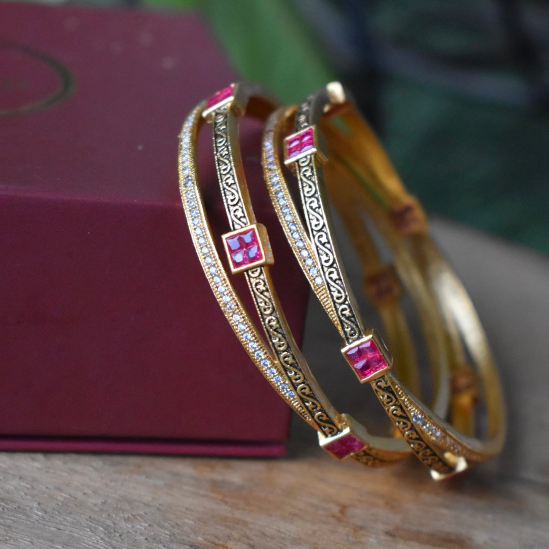 Stacked ruby stone bangles with intricate black enamel detailing
