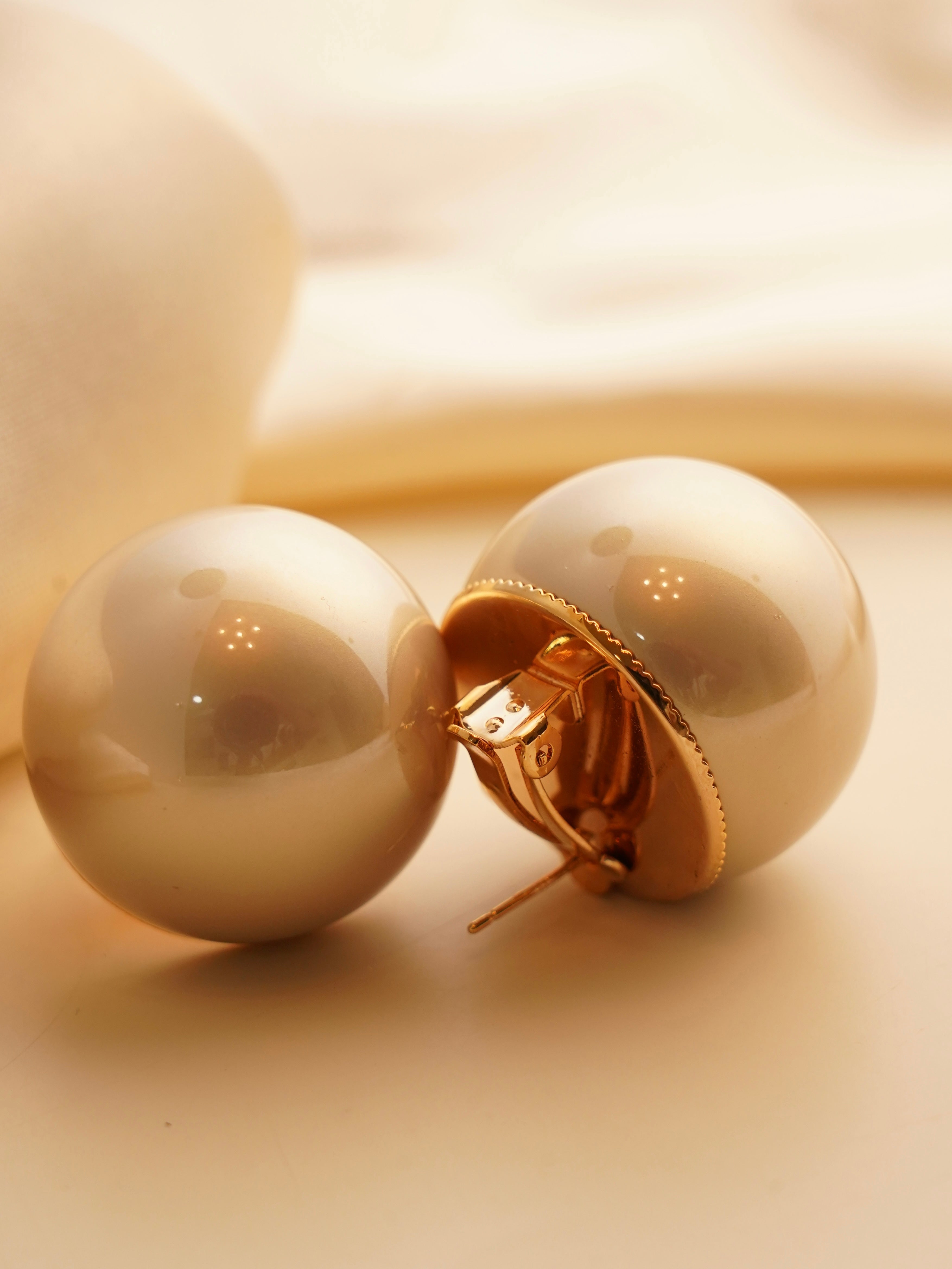 Side view of bold pearl studs showcasing rounded shape and luminous finish