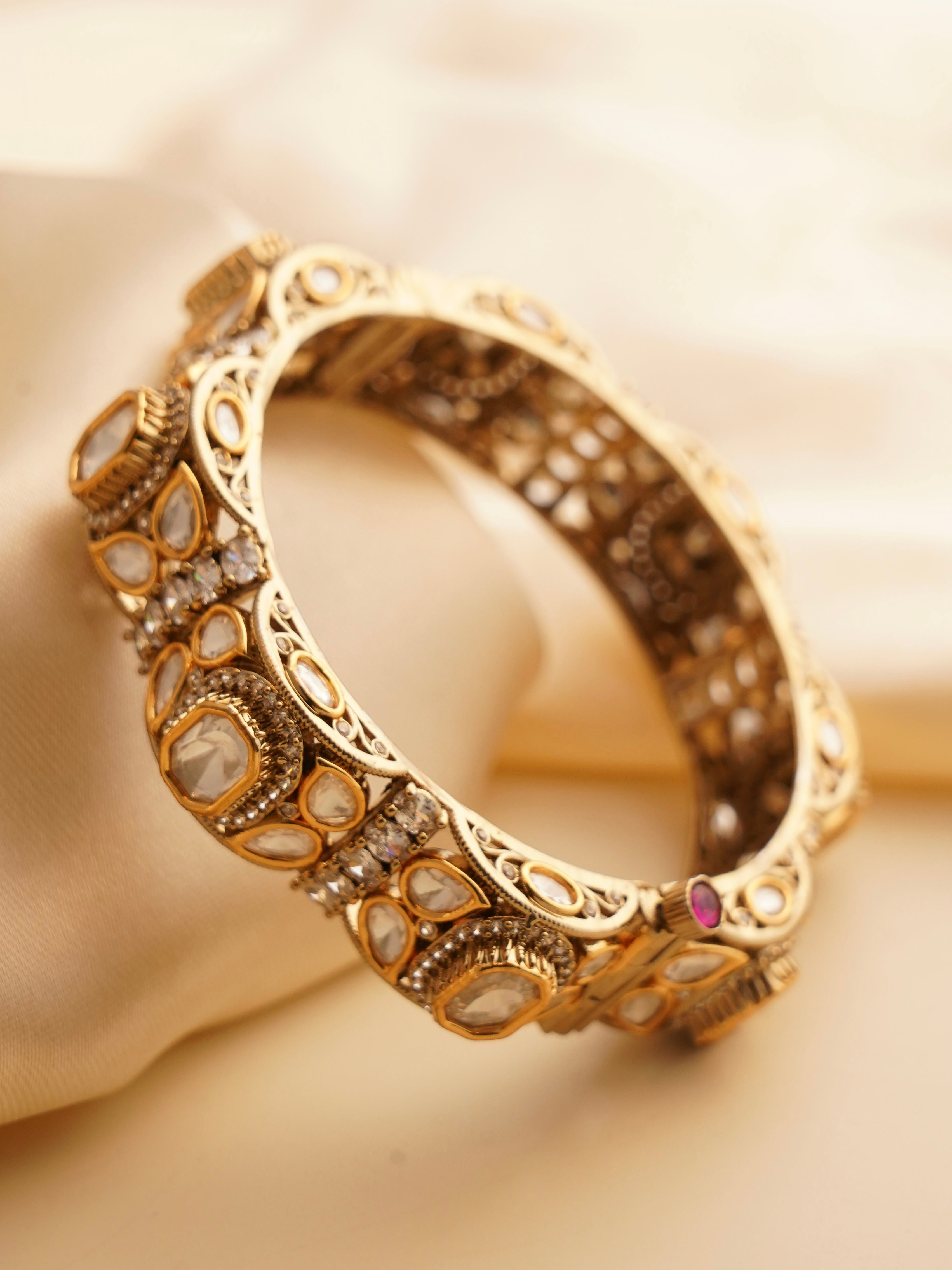 Pair of timeless kundan bangles with ruby highlights and intricate stonework in traditional finish
