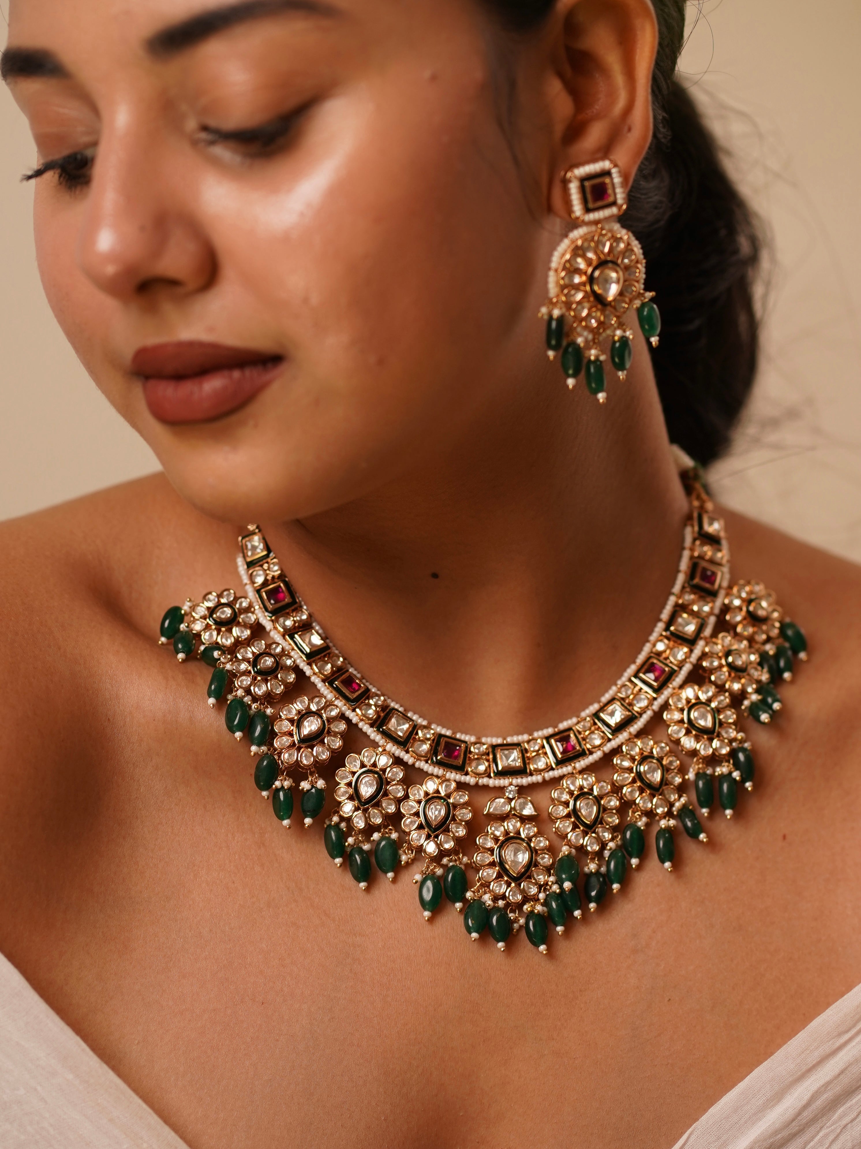 Front view of kundan necklace with deep green beads and ruby accents in regal layout