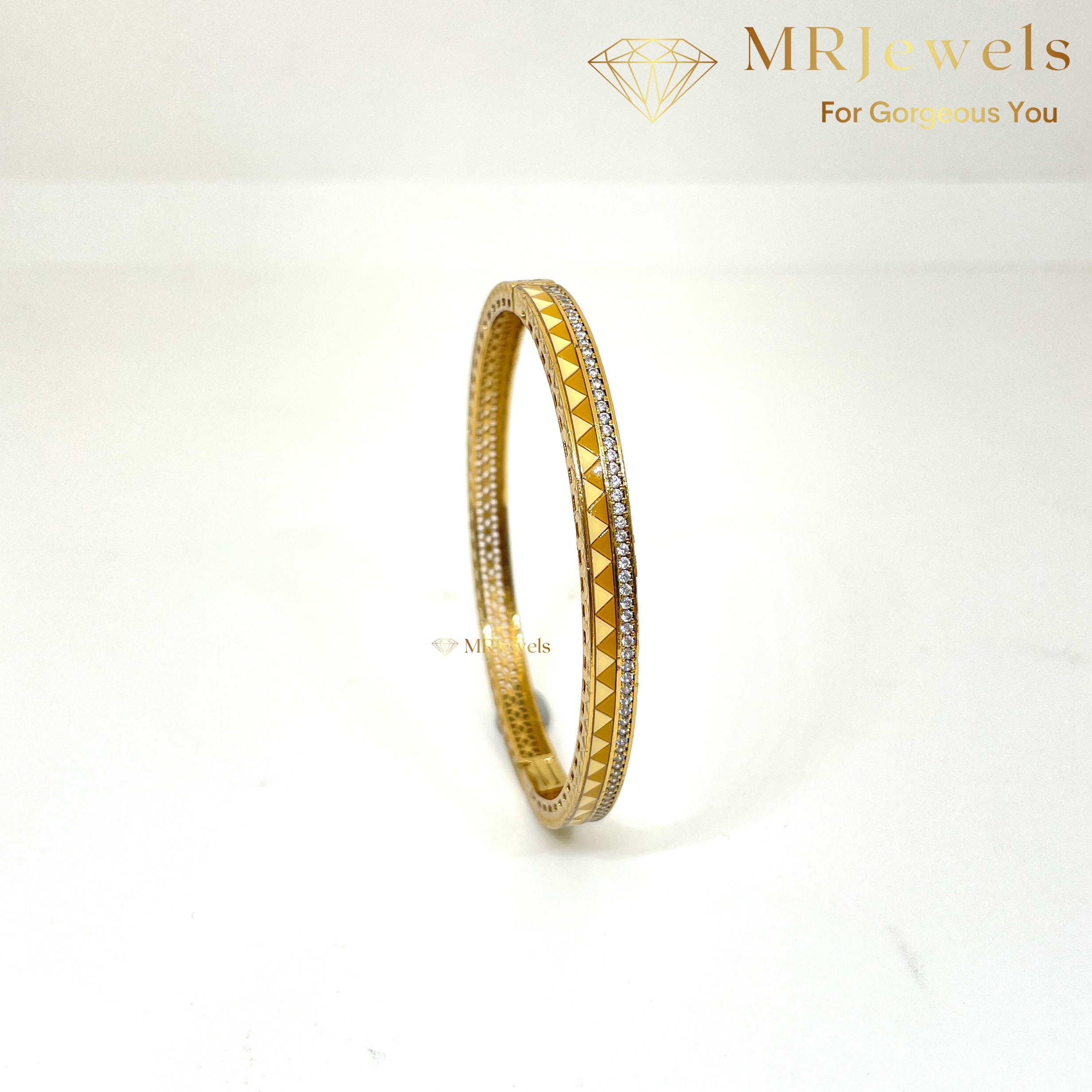 Front view of openable enamel bracelet with diamond-like stones and gold-toned finish