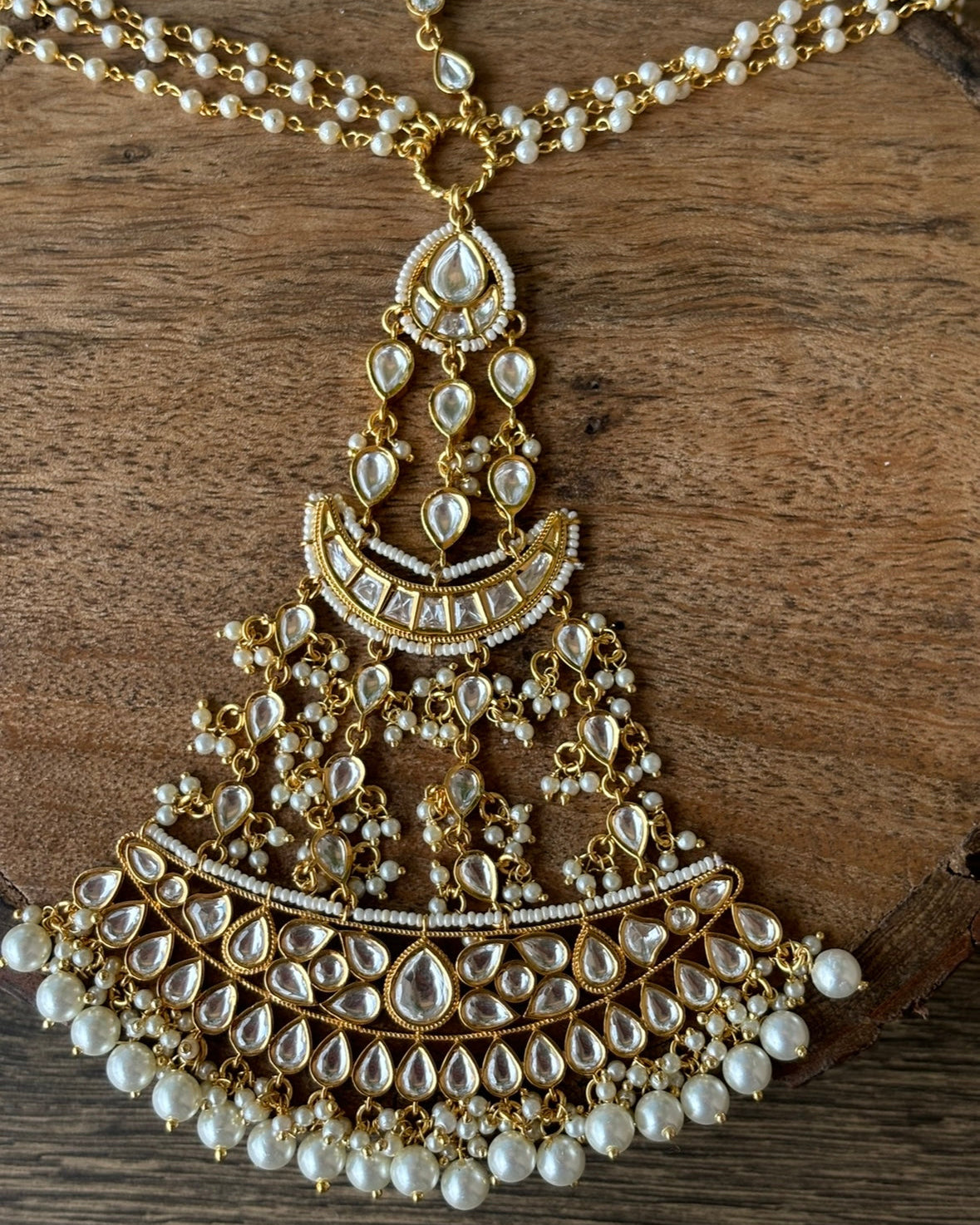 Side view of intricate kundan headpiece with layered forehead bands