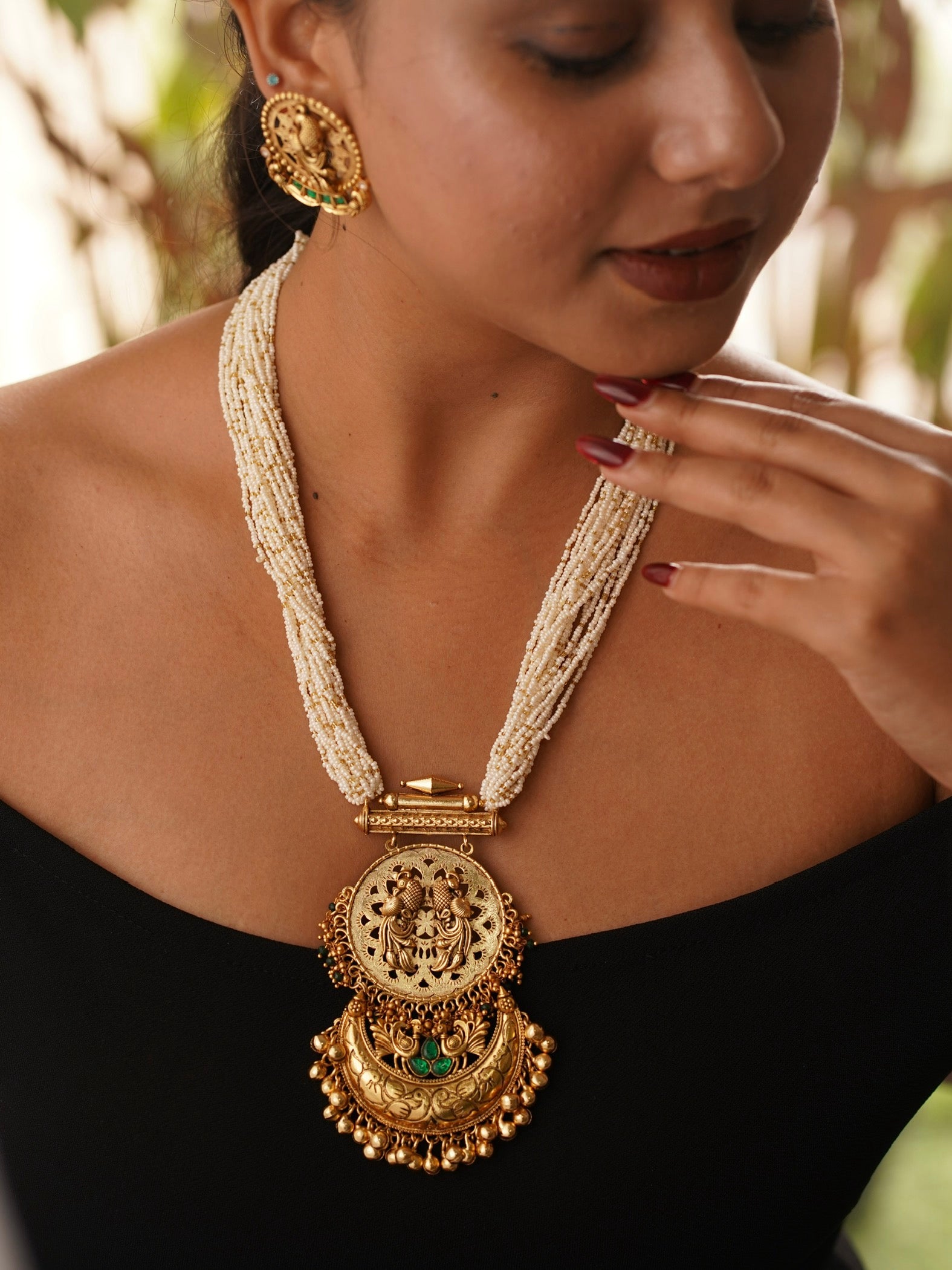 Temple-inspired pearl necklace with twin peacock design and emerald green accents