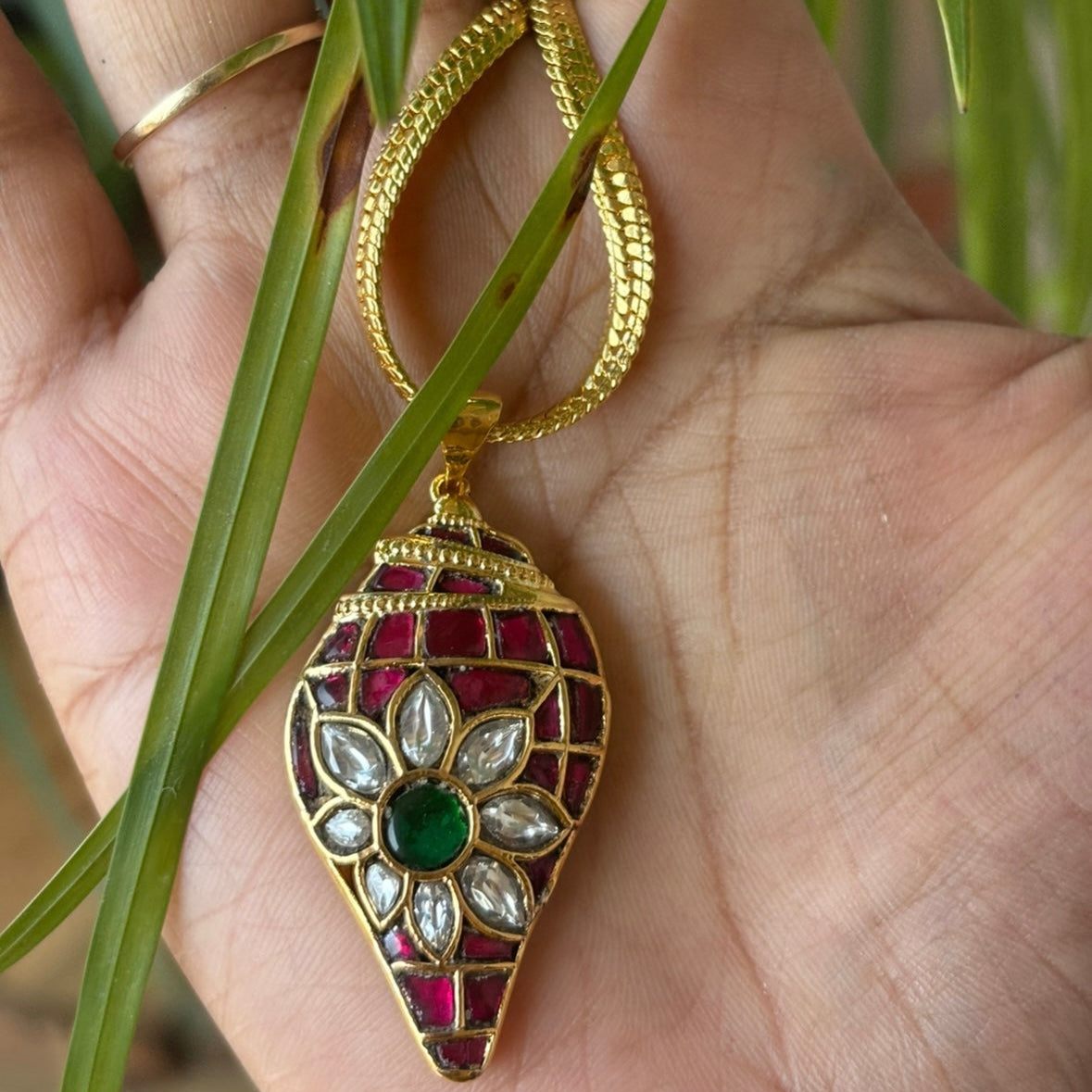 Side profile of handcrafted pendant with gemstone inlay and shank-style structure