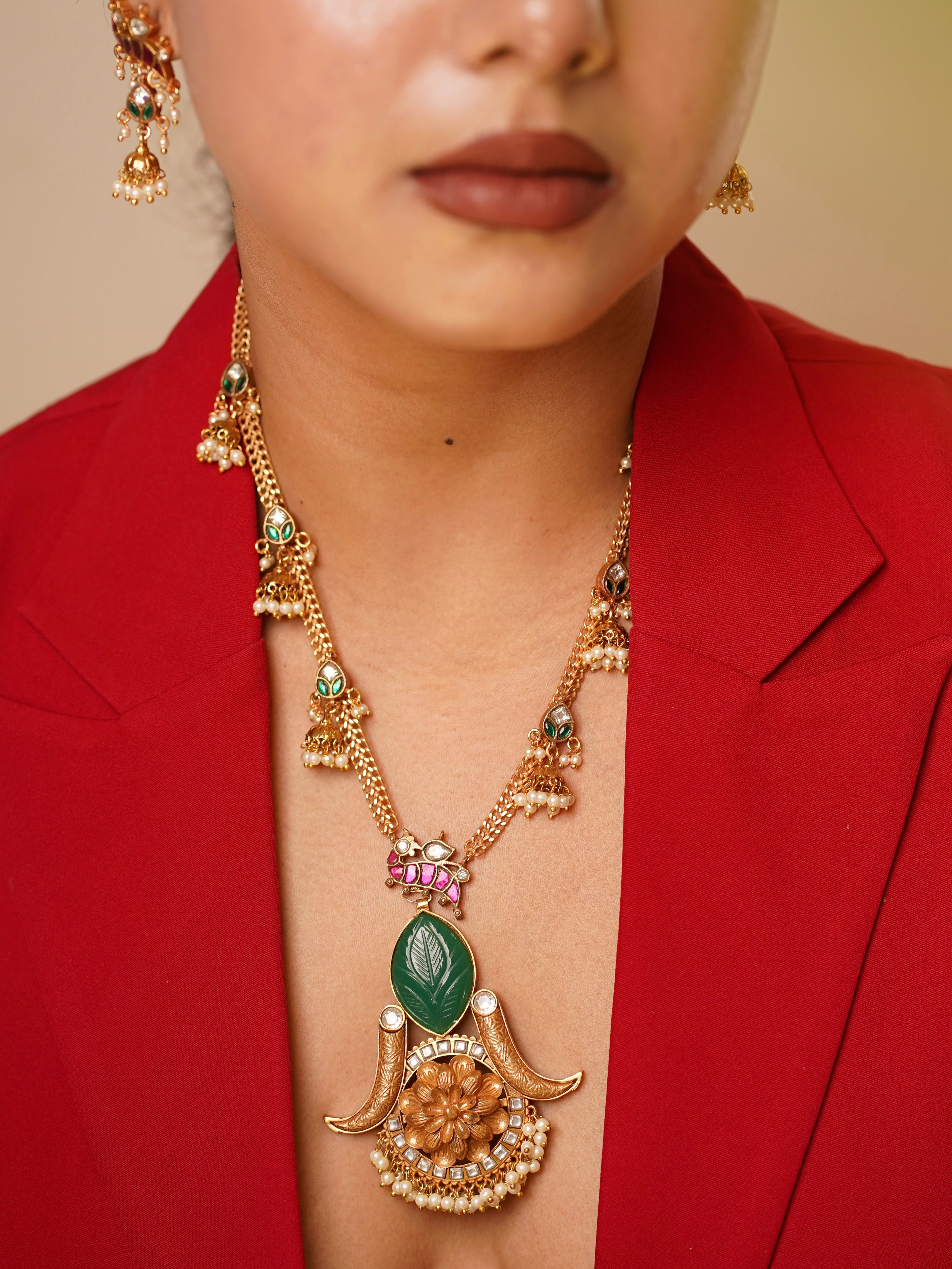 Side view of Noor necklace showing emerald-toned leaves and floral pendant detailing