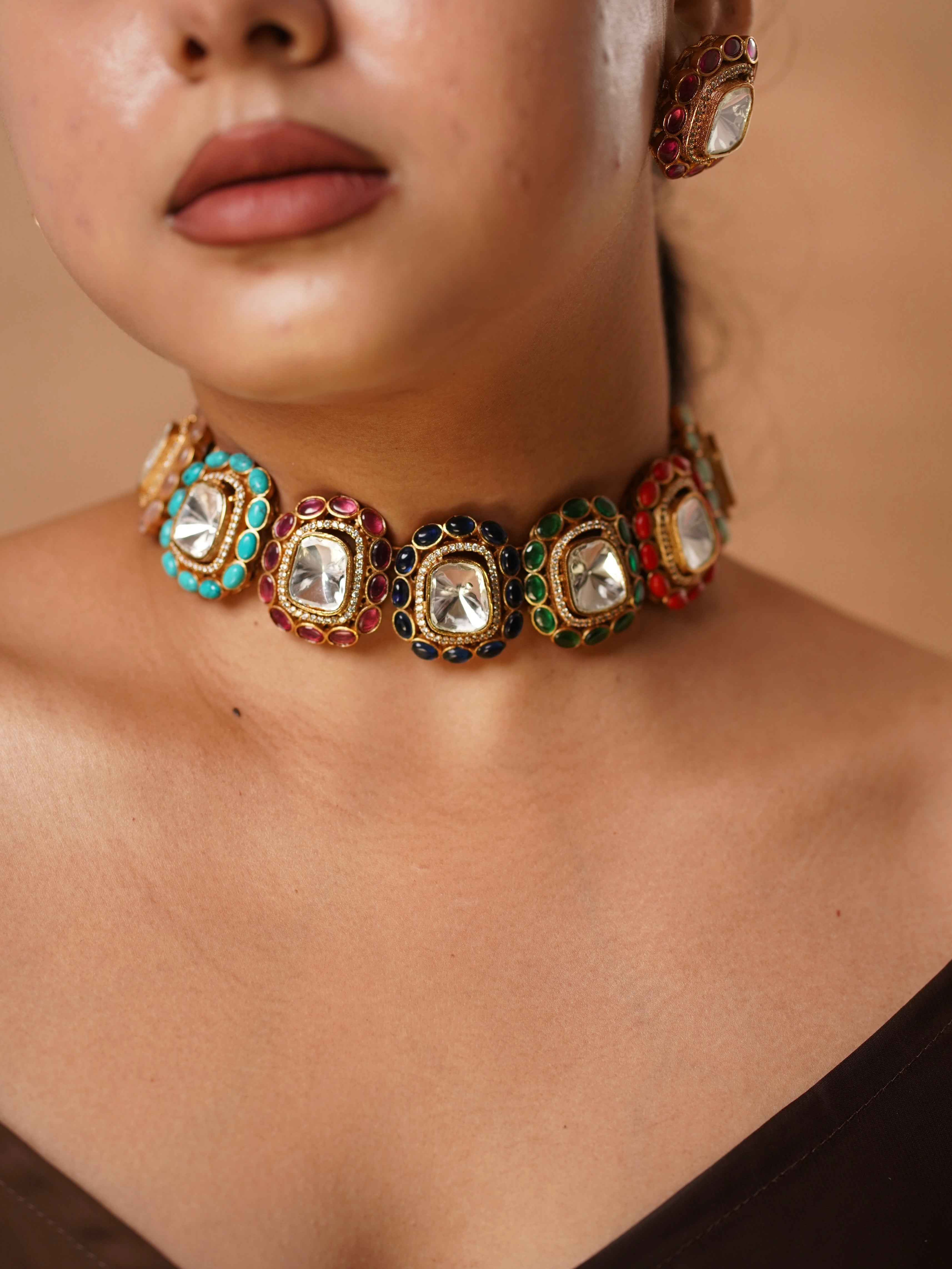 Top-down view of Gem Muse choker showcasing colorful stone inlays and mirror-polished focal point