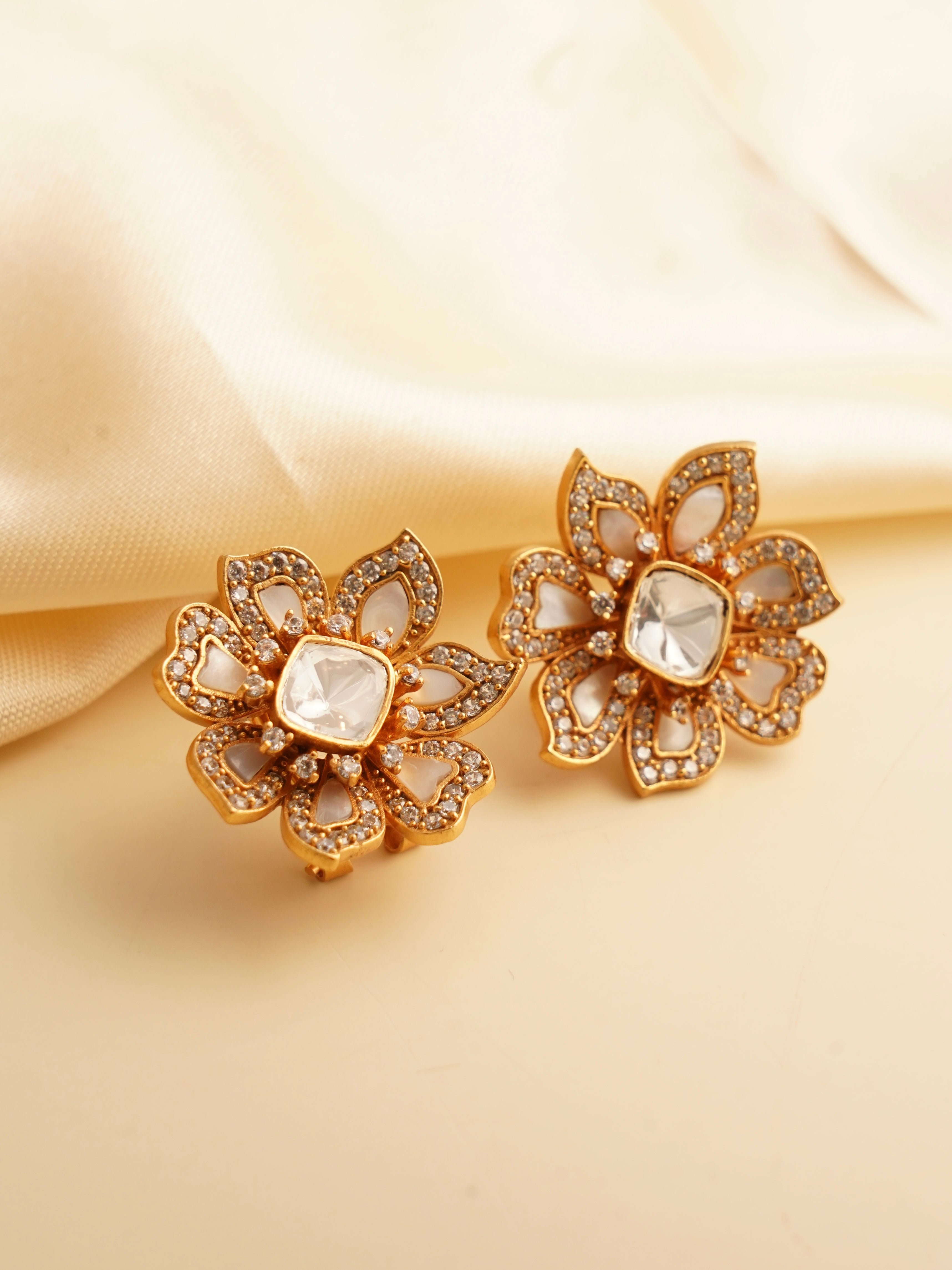 close-up of round moissanite studs with mother-of-pearl detailing on a neutral background