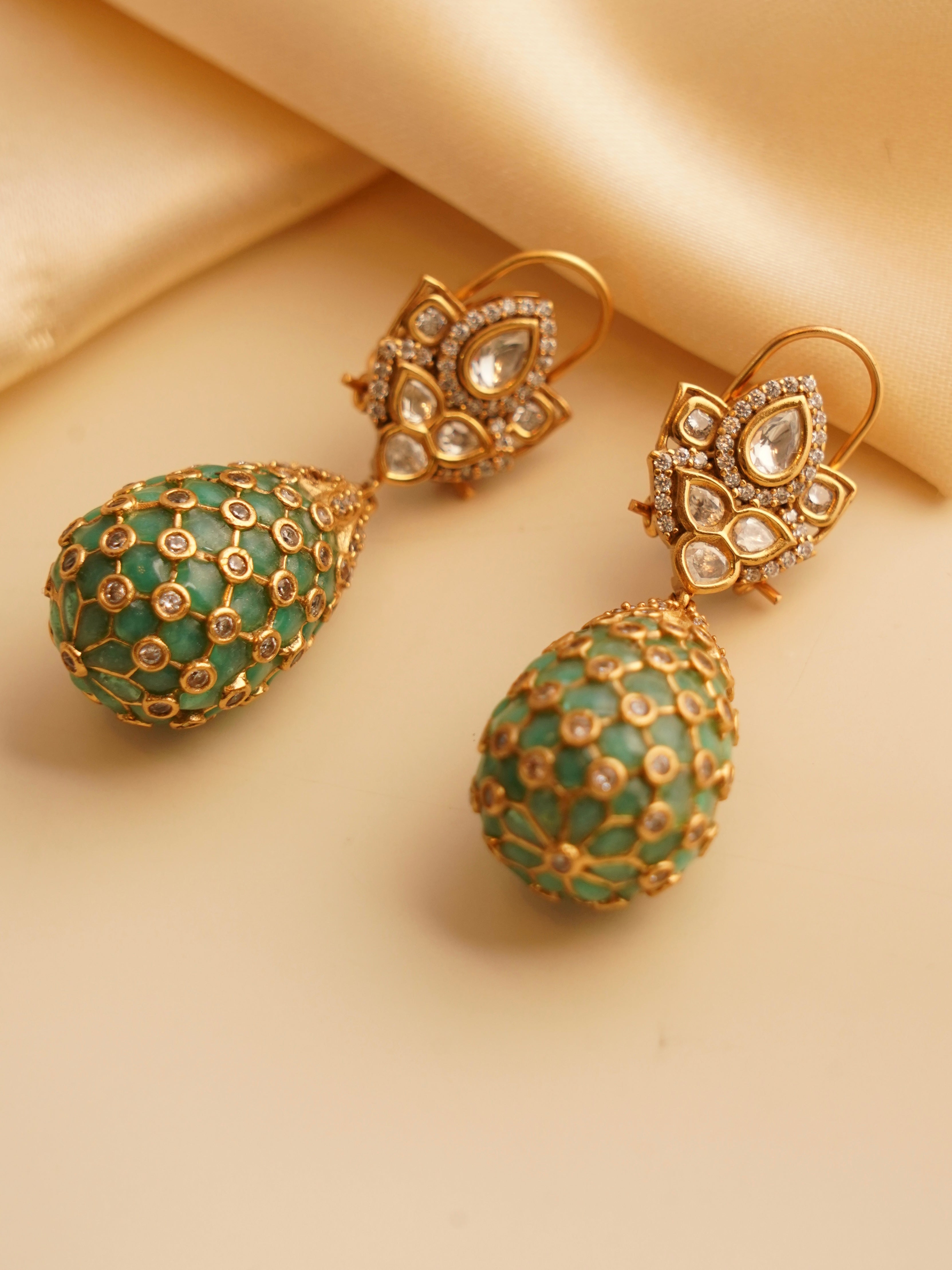close-up detail of gold-toned polki earrings with dangling design