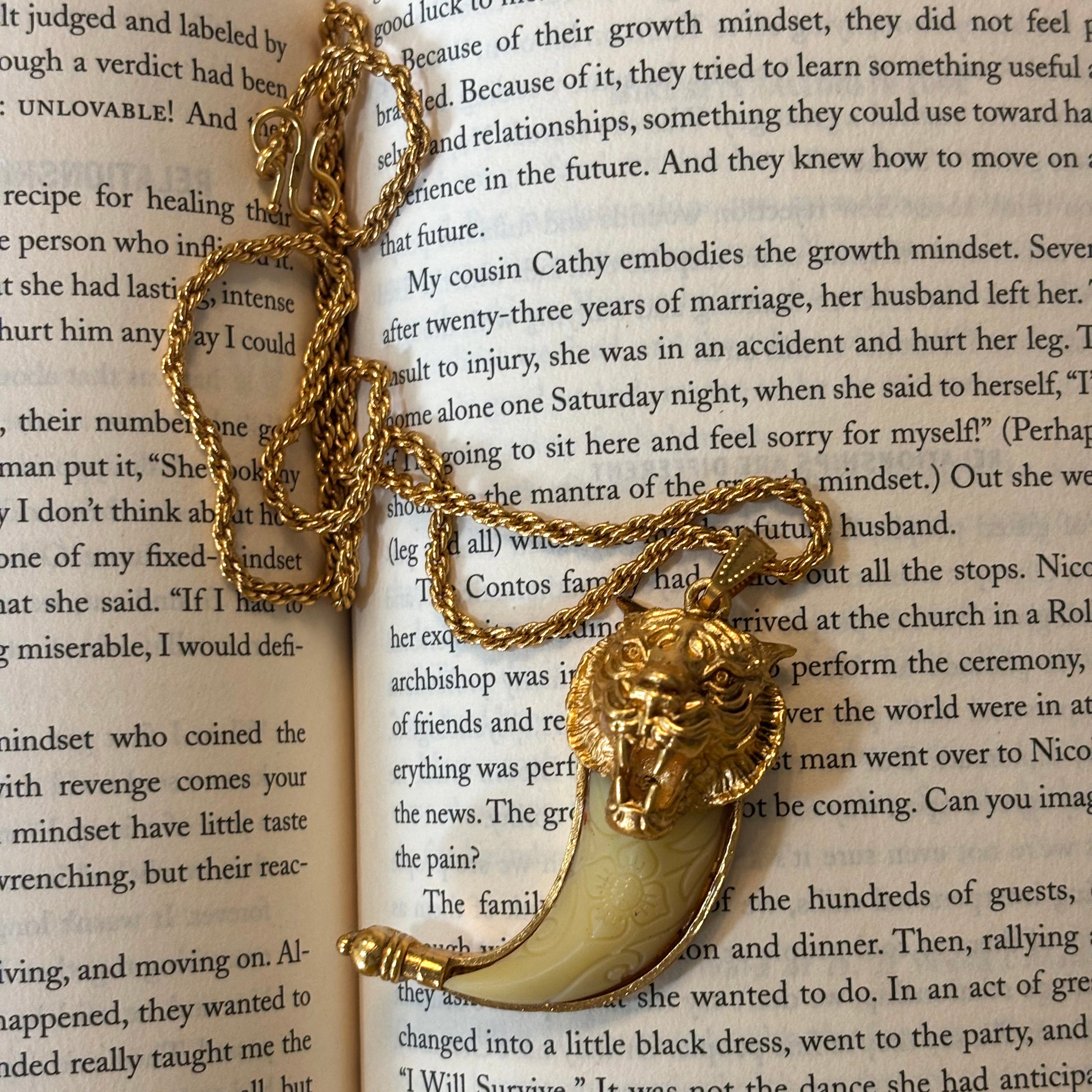 Side view of tiger tooth pendant with long chain and polished finish