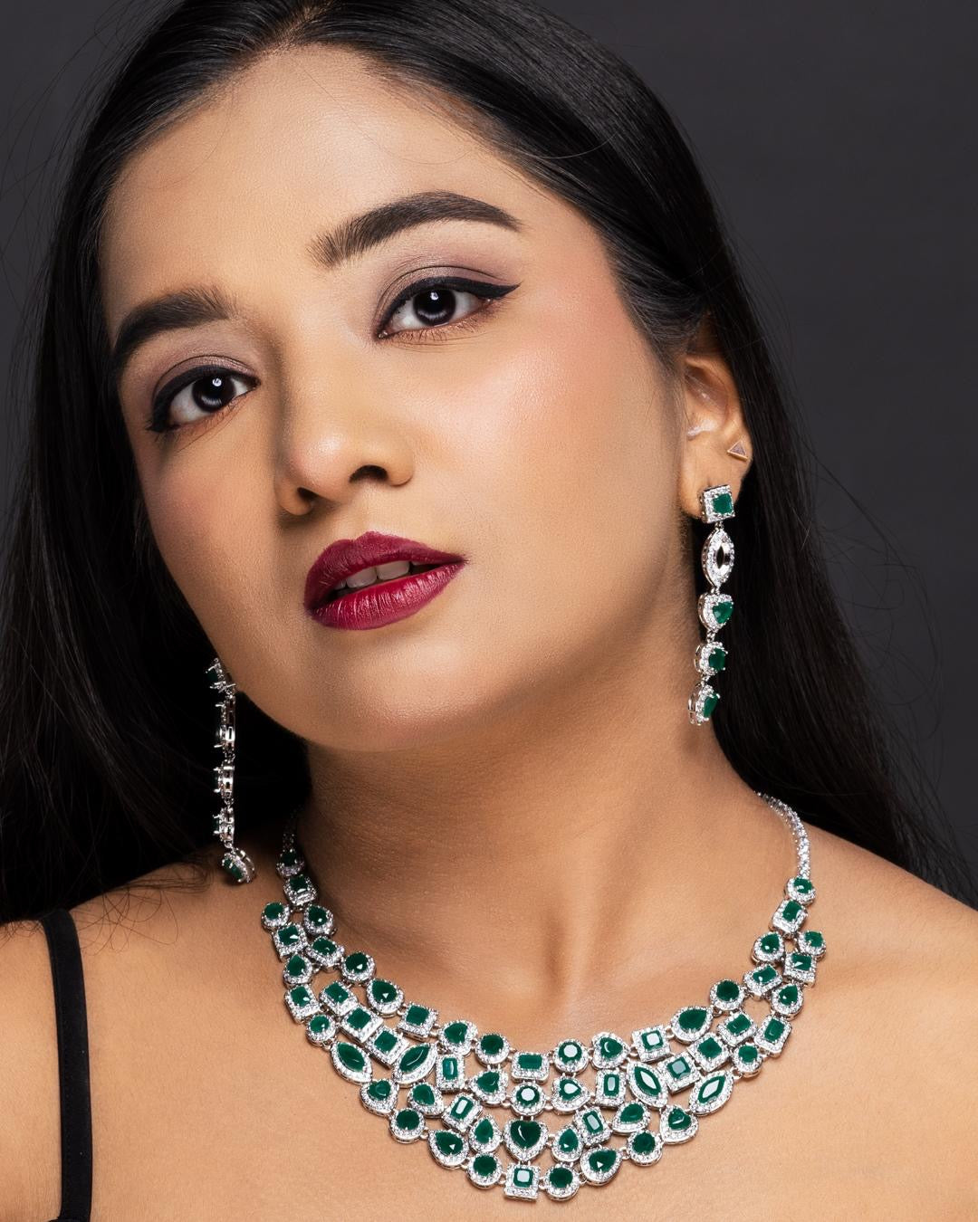 Angled view of bridal emerald diamond necklace with silver-toned plating