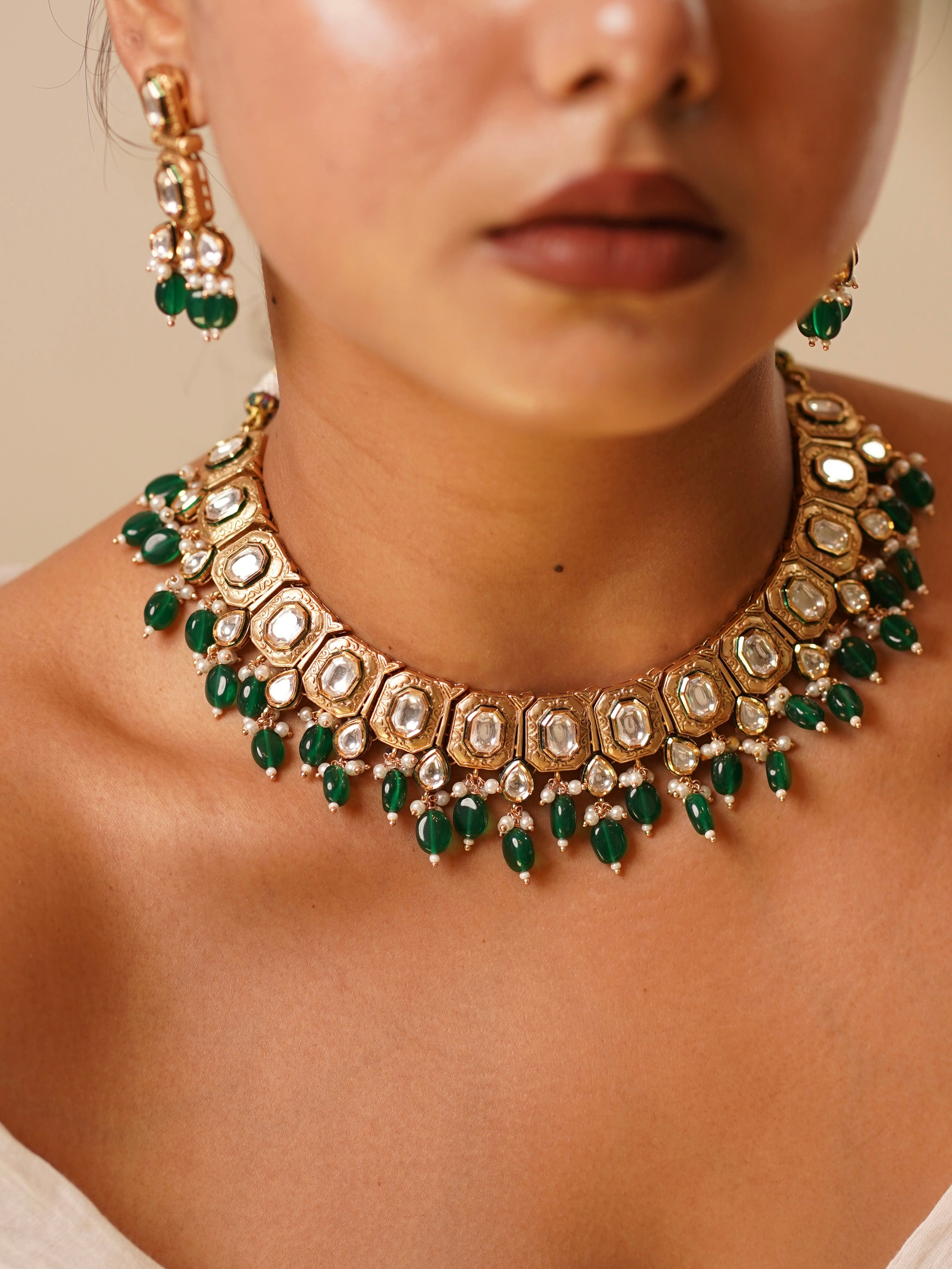 Model wearing Emera Kundan Royale set with uncut kundan choker, cascading green beads and matching earrings