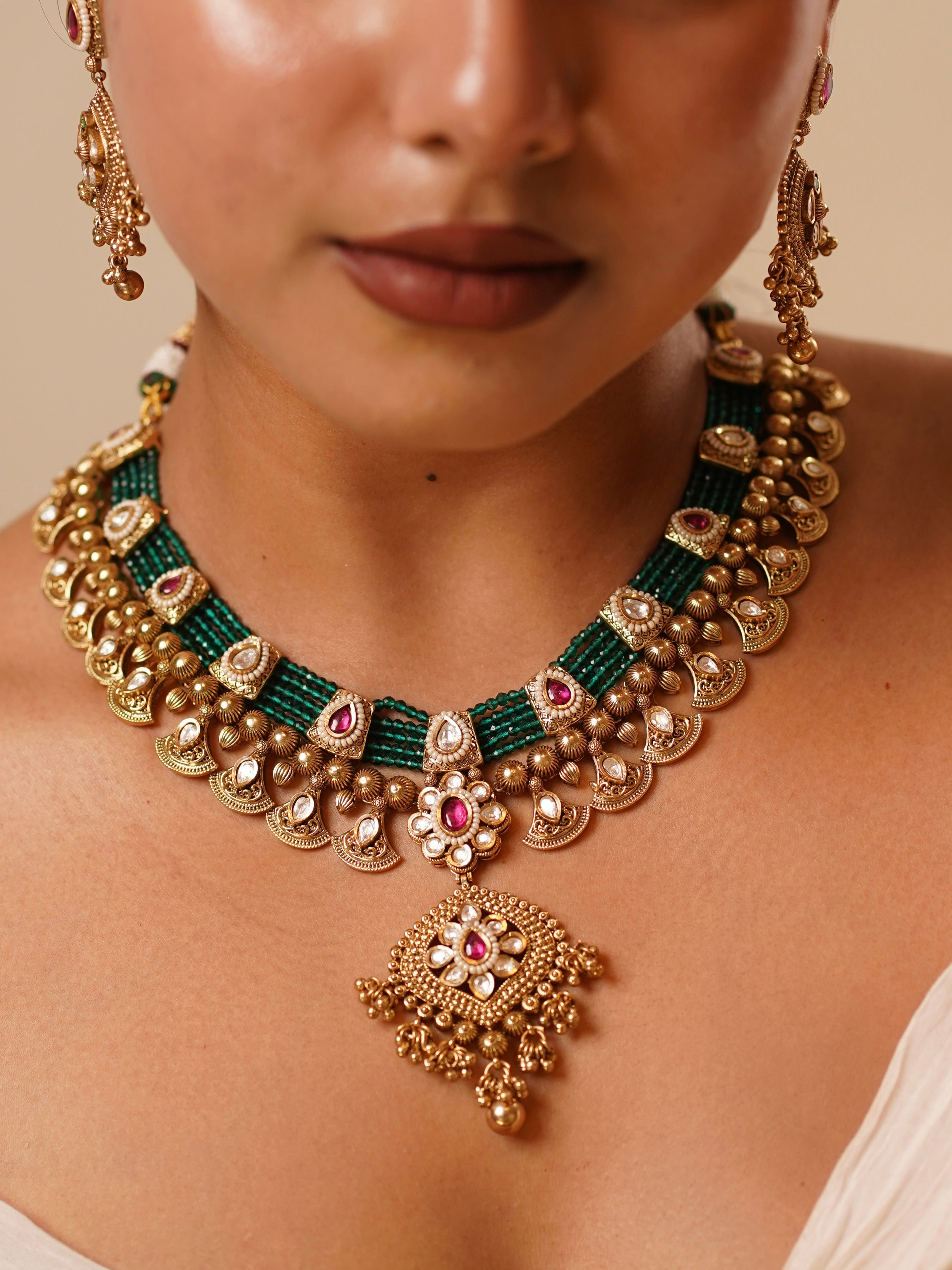 Statement pendant with antique finish from Meher choker set featuring emerald and ruby hues