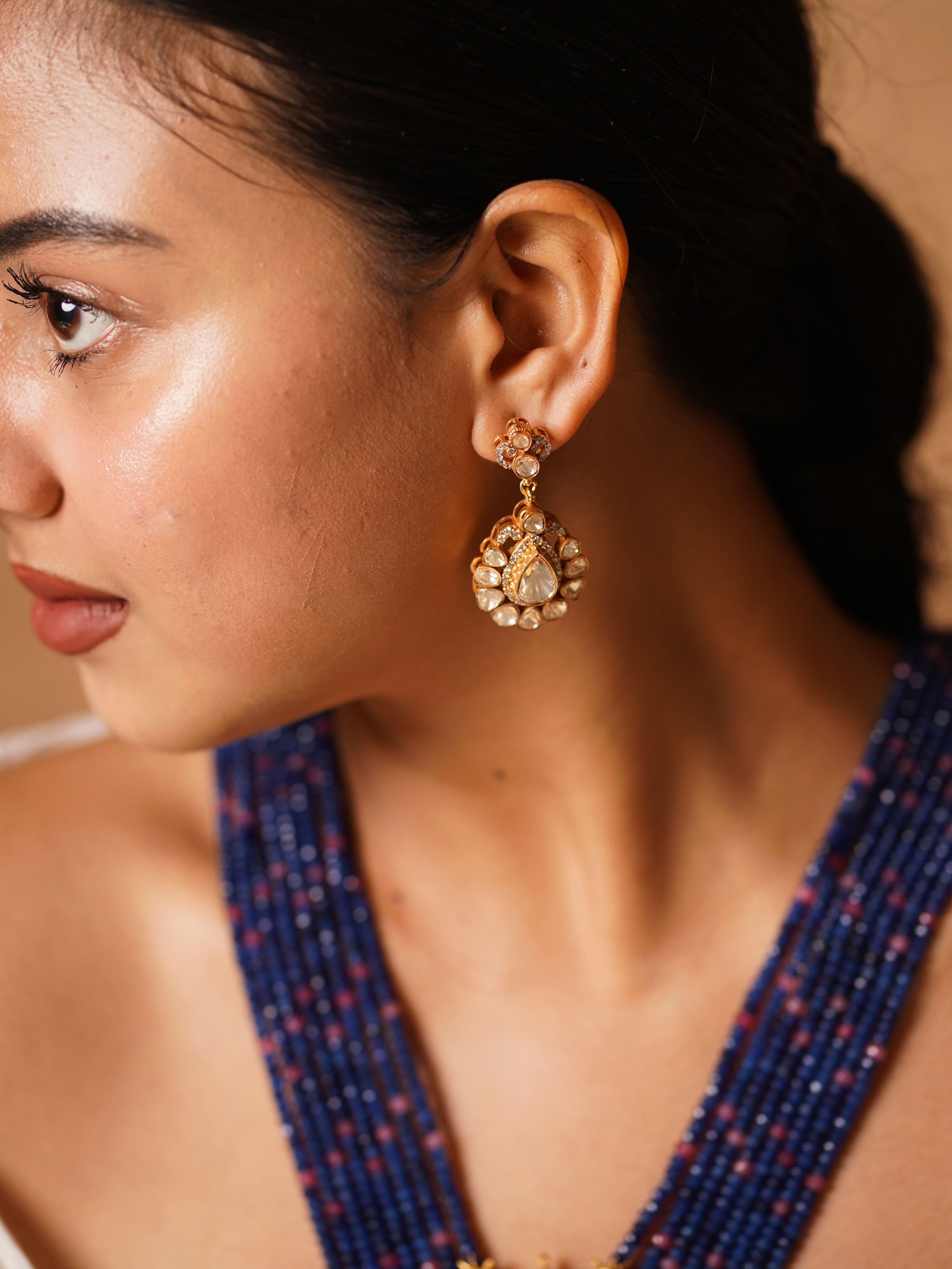 Close-up of kundan pendant with peacock enamel and drop details