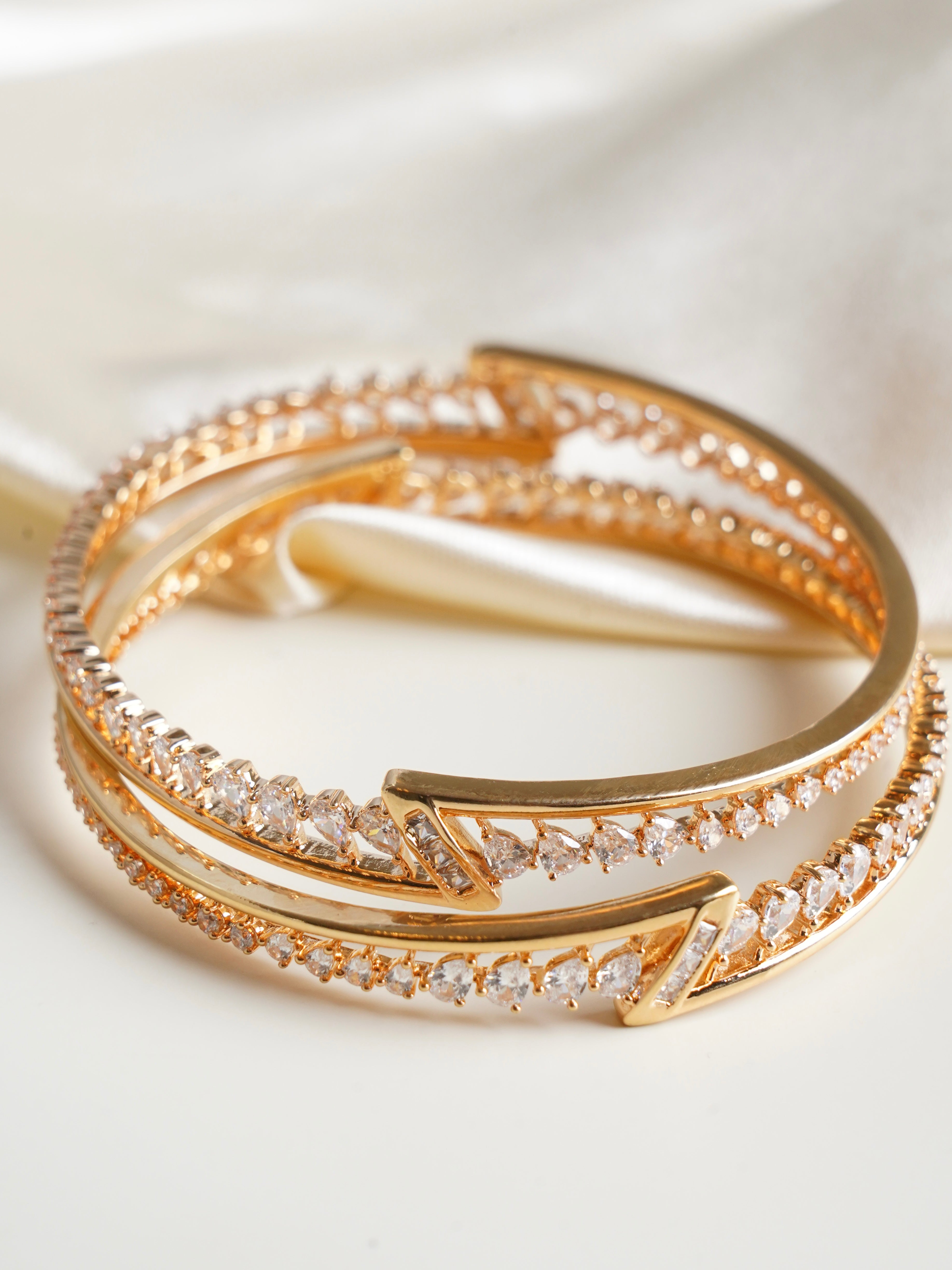 Side view of diamond-cut gold bangles showcasing detailed reflective pattern