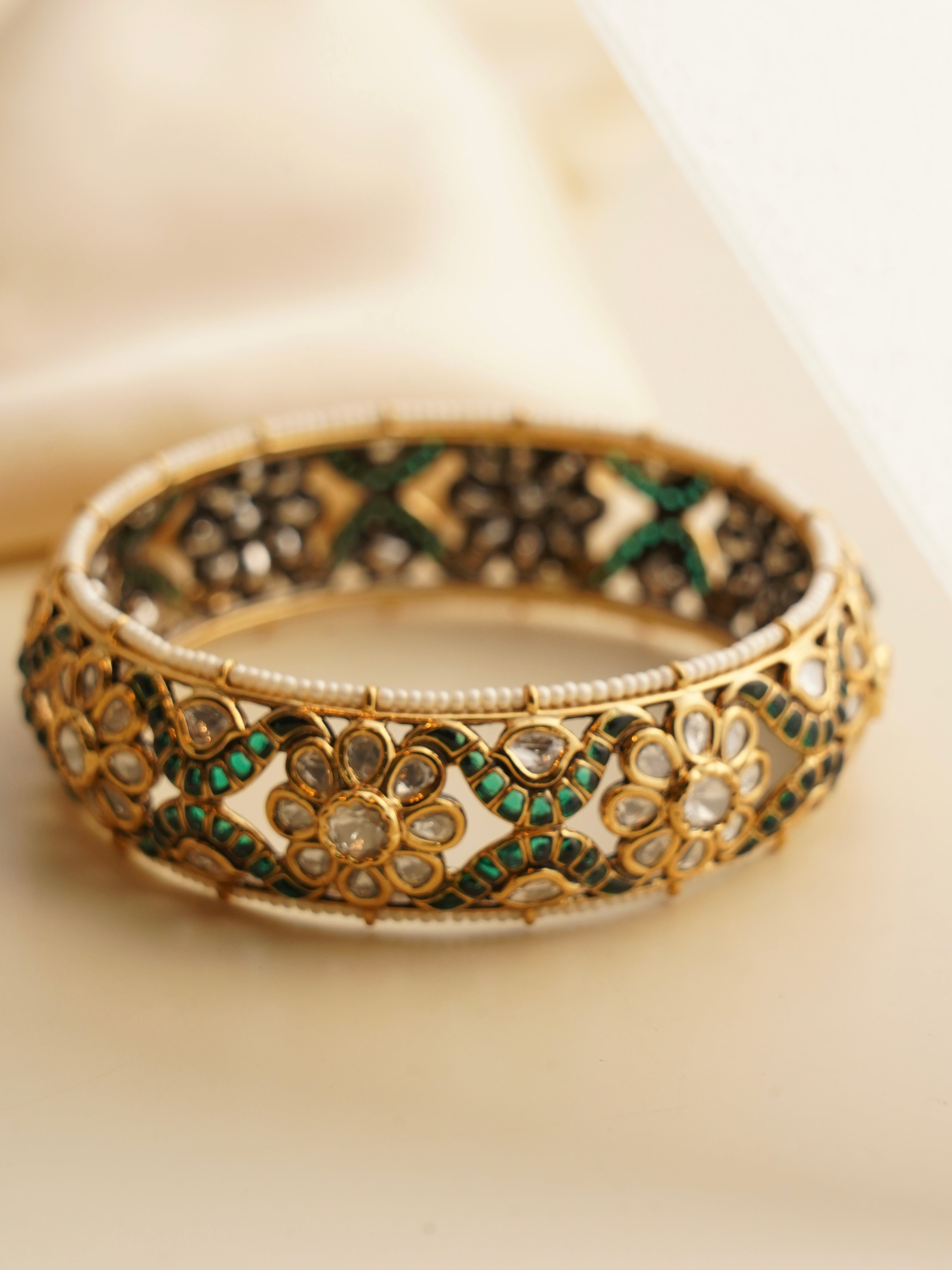 Side angle of moissanite diamond kada with uncut stones in ornate gold setting