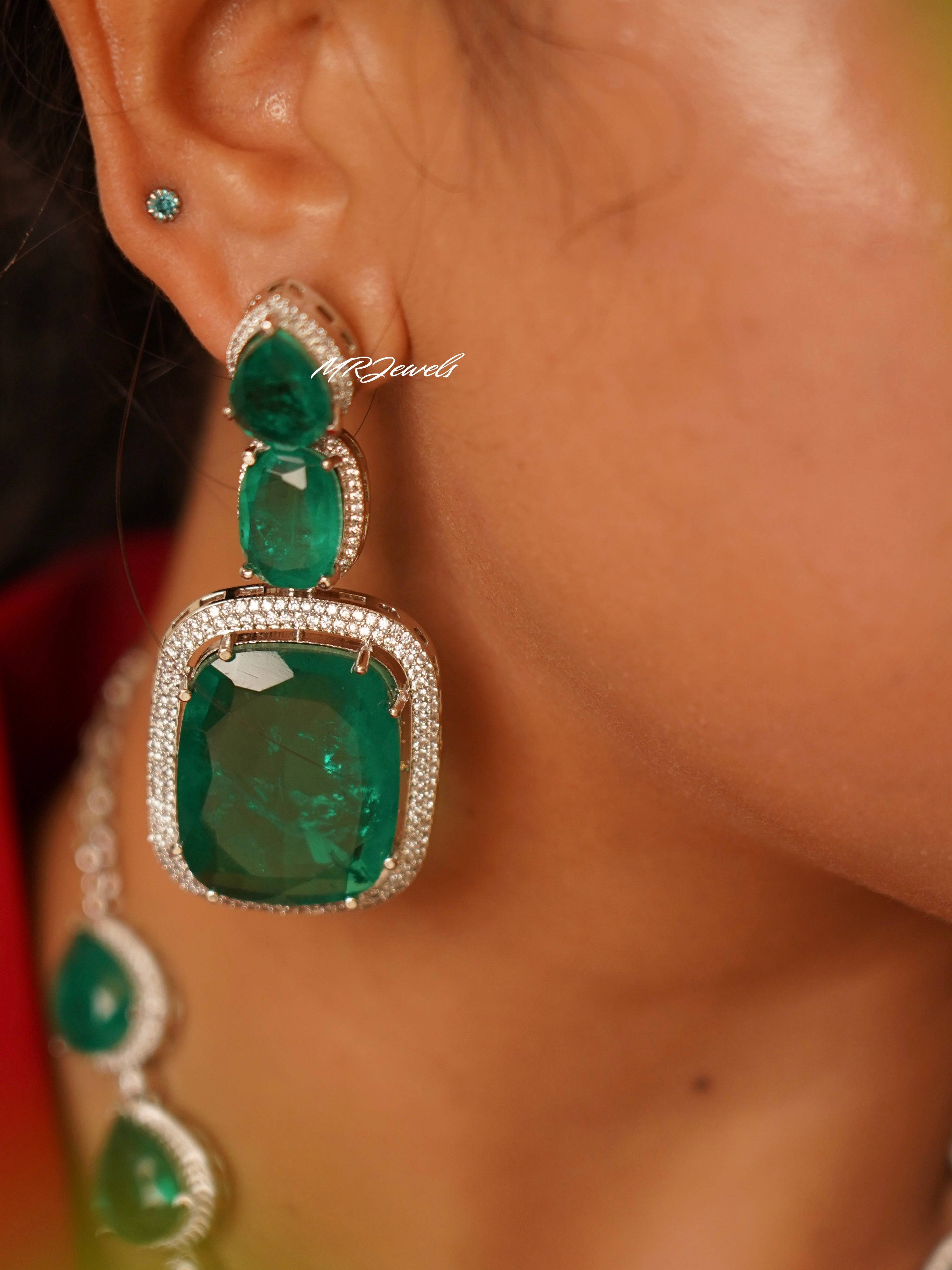 Side angle of emerald heirloom earrings and necklace showing matching stone arrangement