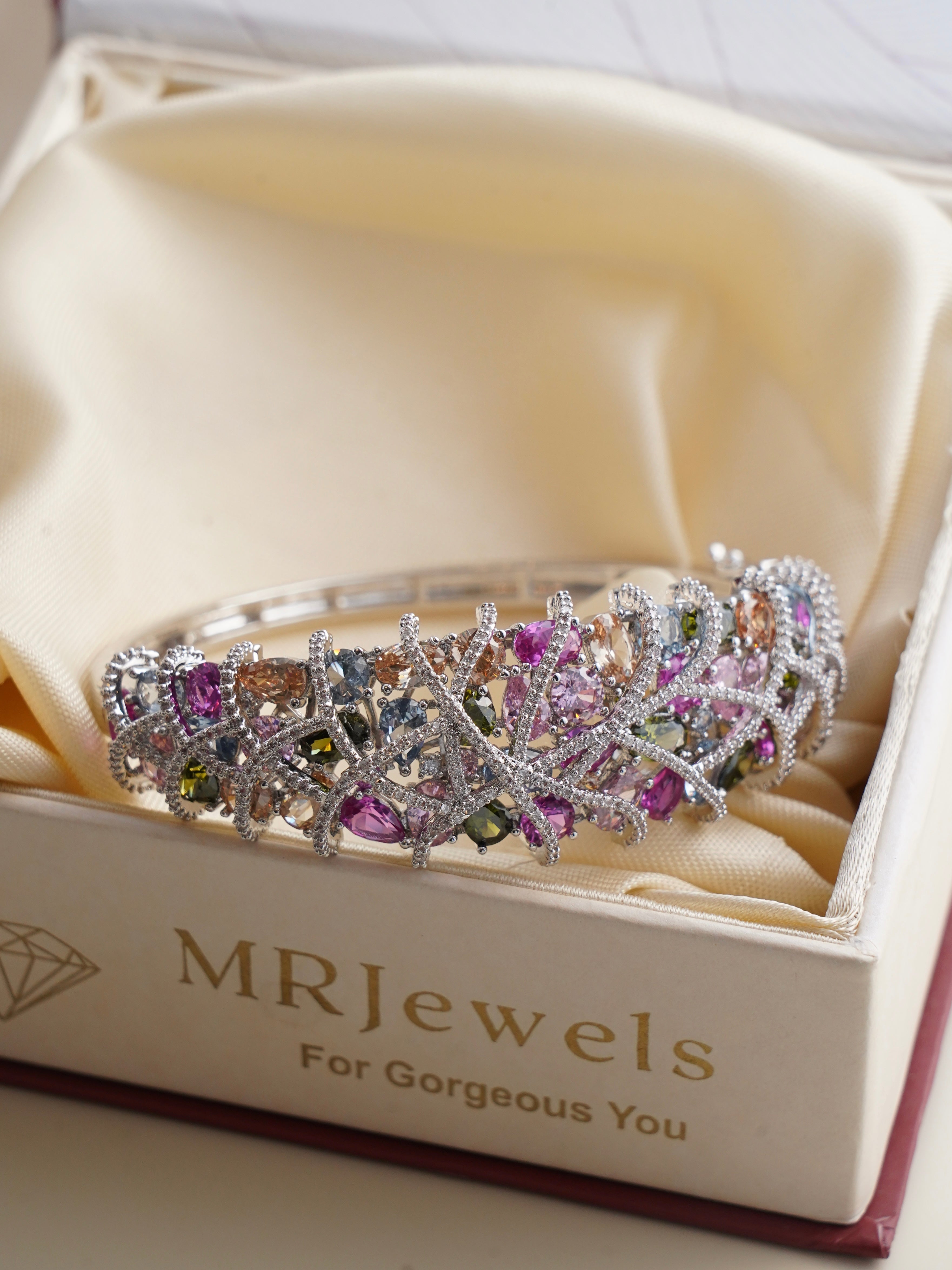 Side view of sculpted bracelet with amethyst, topaz, peridot, and rose quartz stones