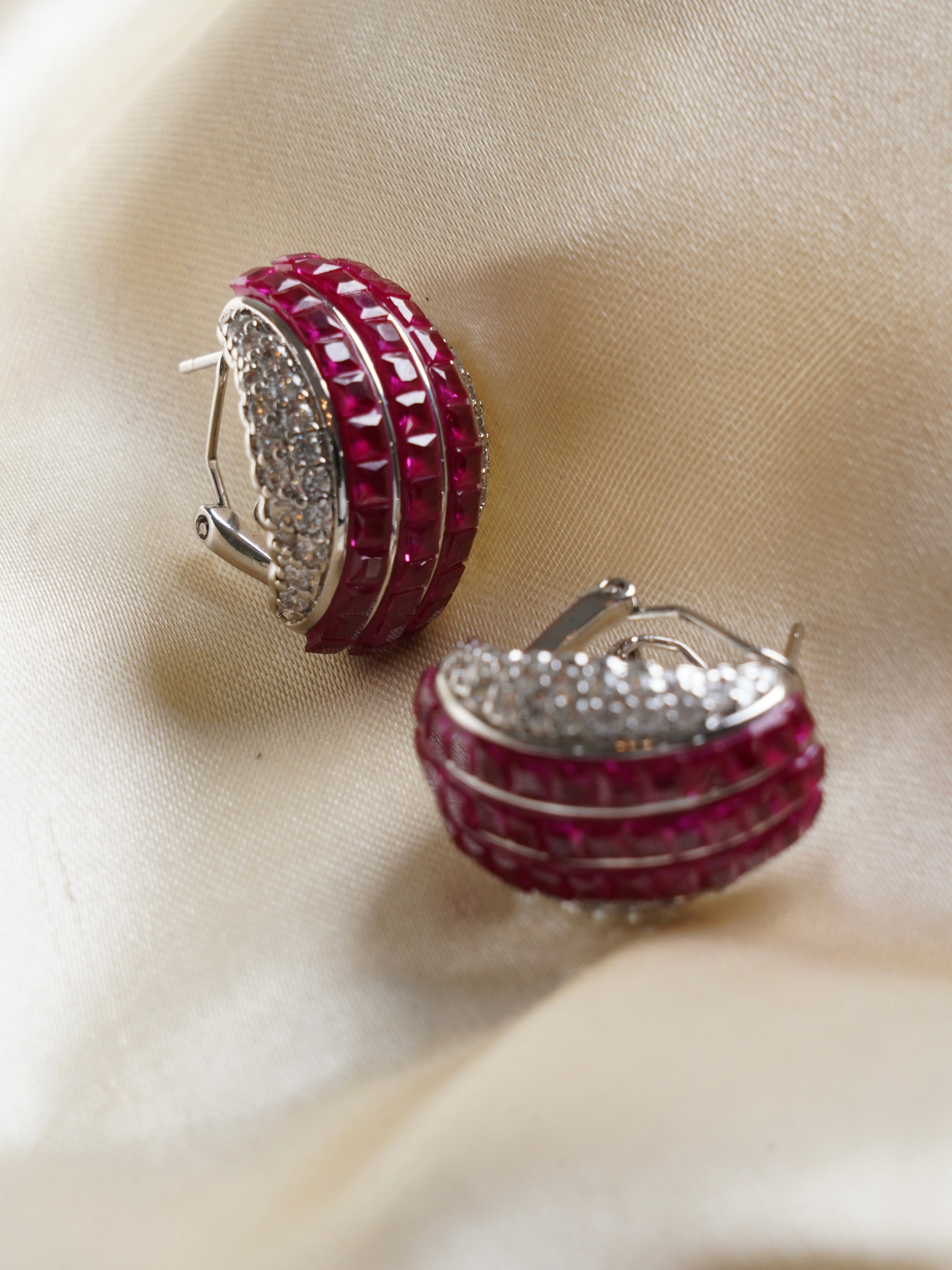 Close-up of luxe gemstone studs with ruby core framed by intricate multicoloured crystal border