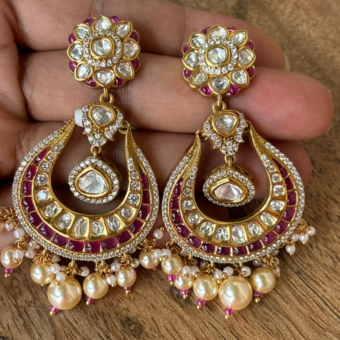 Front view of crescent drop earrings with kundan stones and gold polish