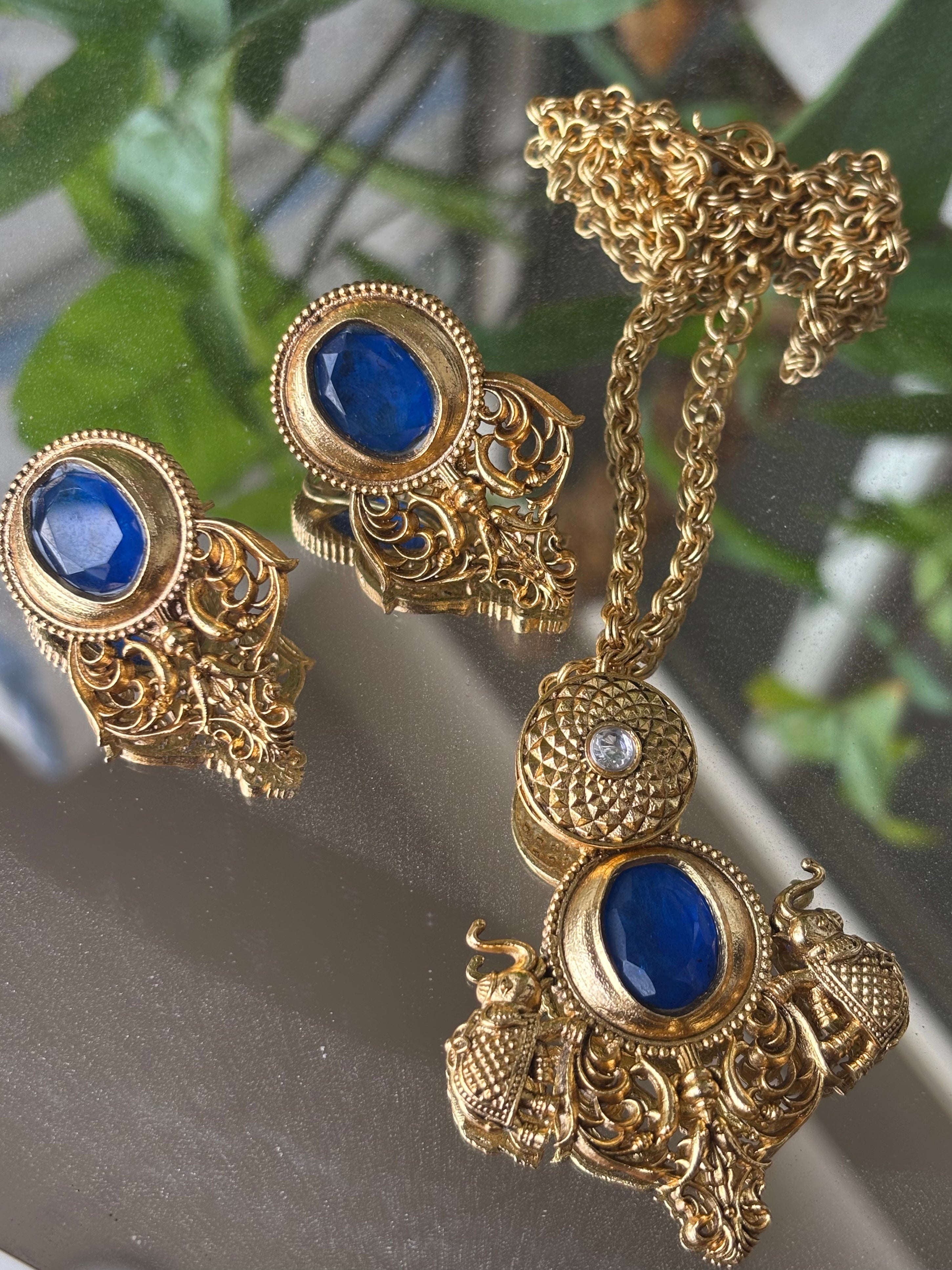 Close-up of matching amrapali earrings and pendant showcasing emerald and ruby options