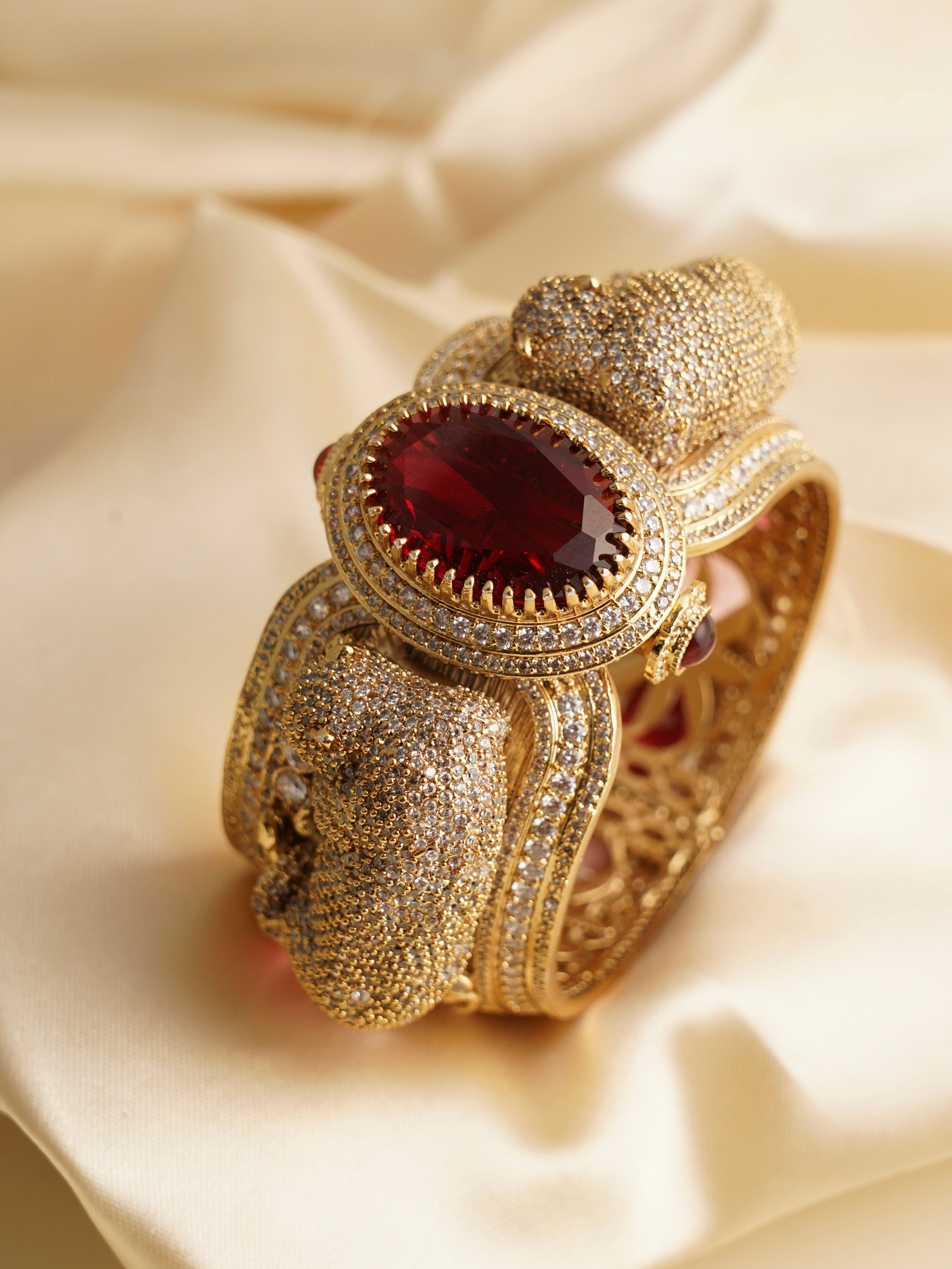 Top view of sculpted bangle showing ruby centerpiece framed by precision-set zircons and lattice band