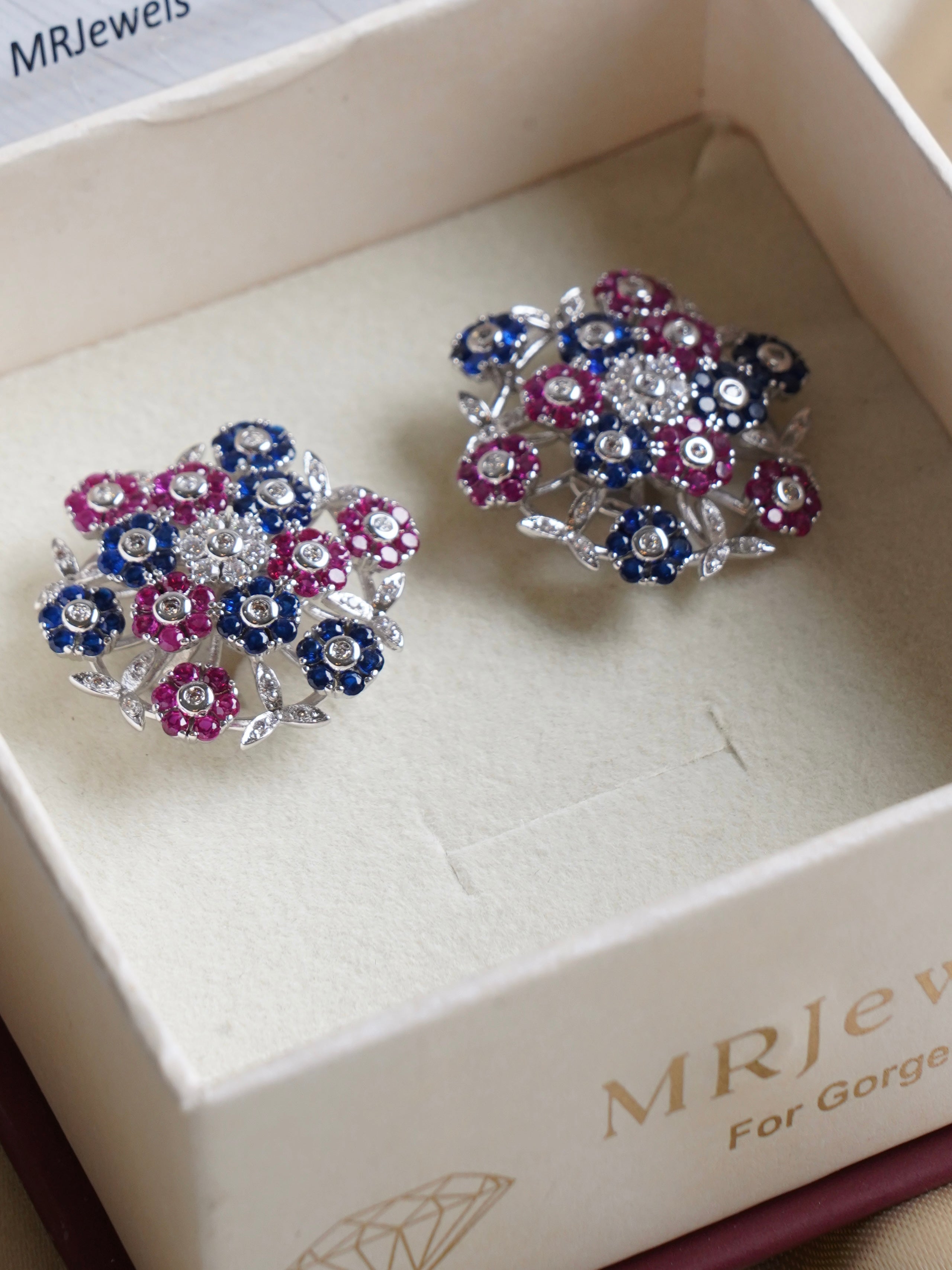 Seraphina fleur constellation studs with blue and pink cubic zirconia flowers in a jewellery box
