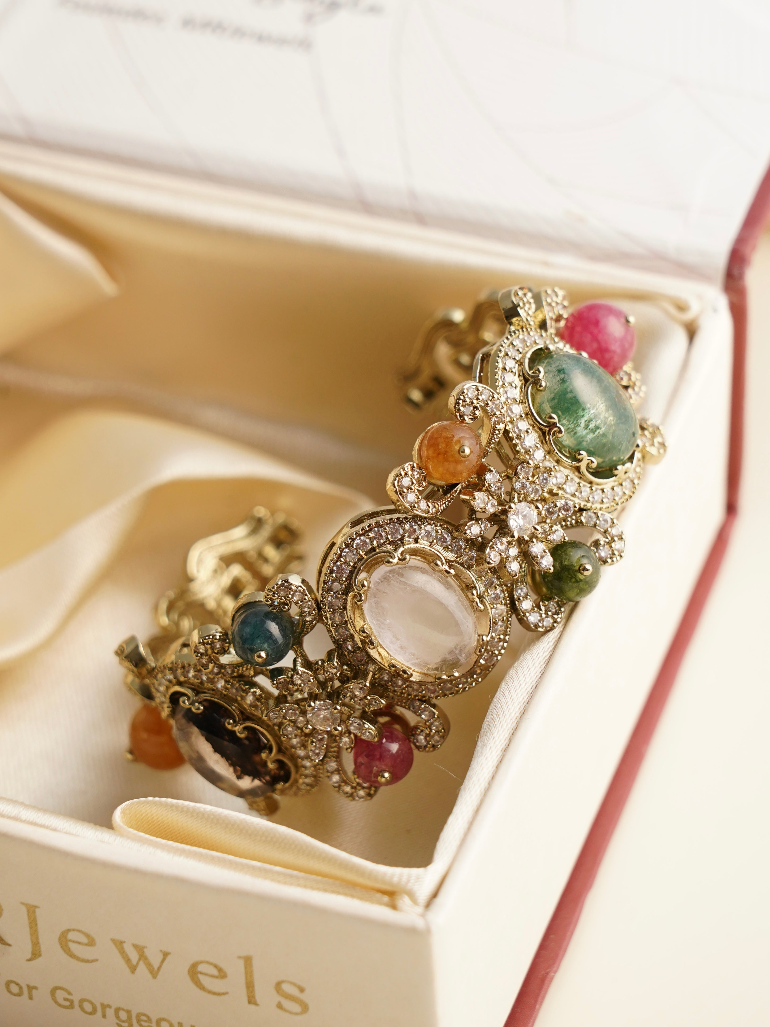 Side profile of navratna kada showcasing vibrant gemstones and intricate polki craftsmanship