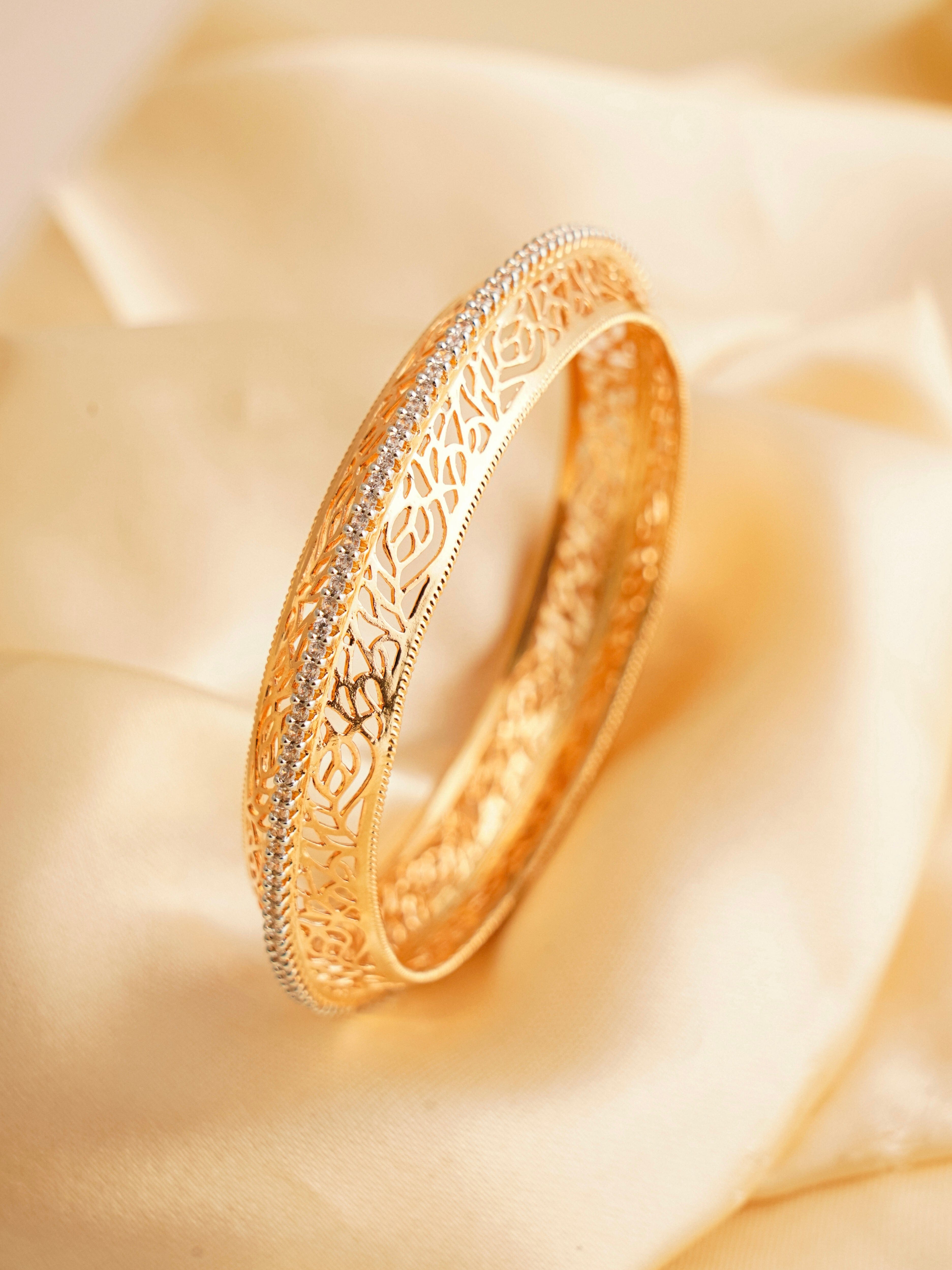 Front view of goldlike kada with intricate diamond-cut filigree detailing on copper base