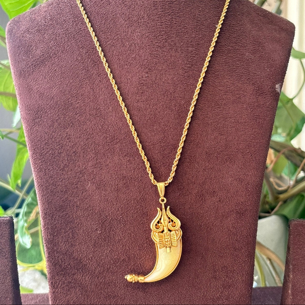 Detailed shot of spiritual trident pendant with polished finish and stone accent