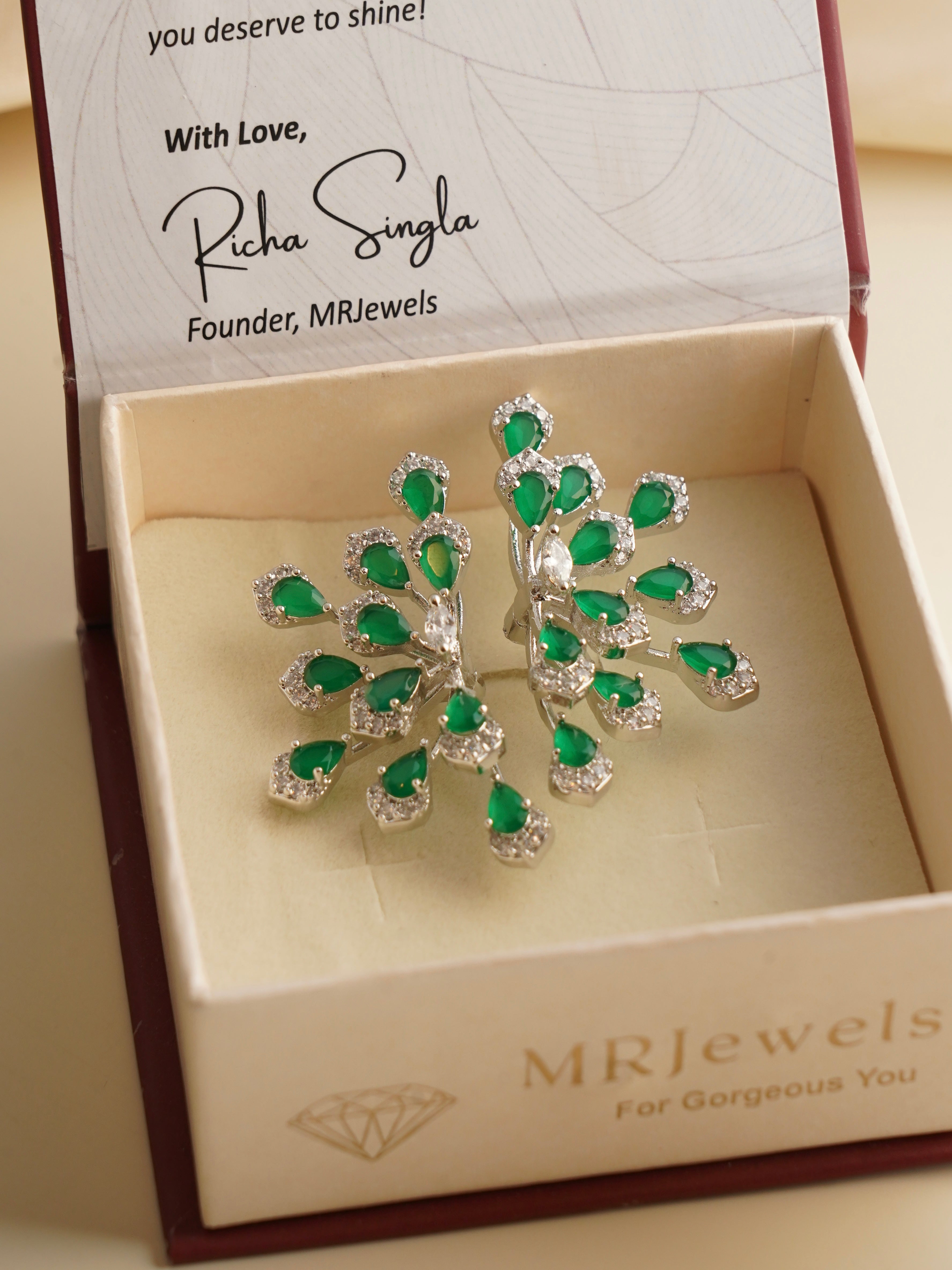 Close-up of emerald cocktail ring with radiant green cluster and stone-studded band