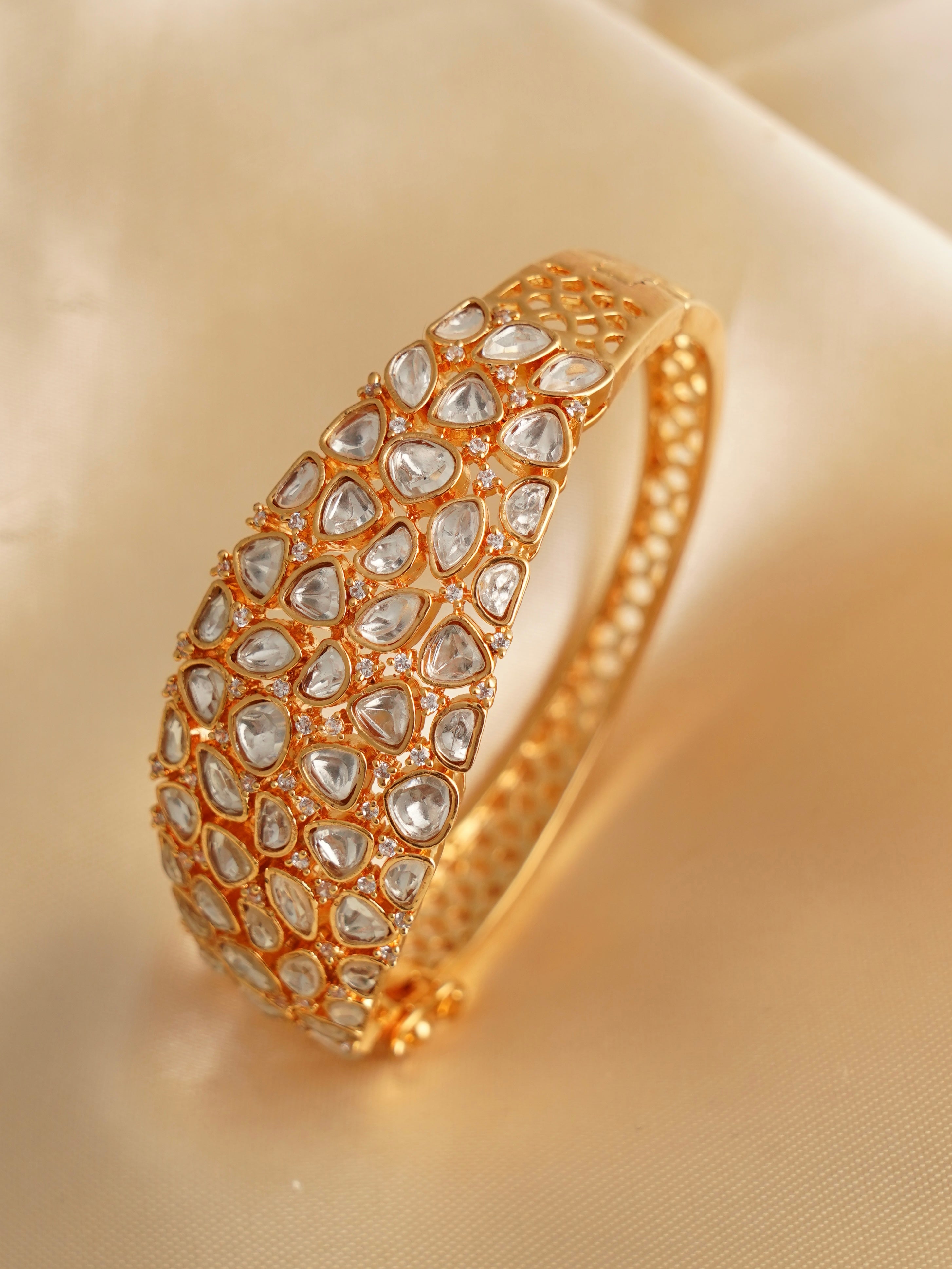 Close-up of traditional kundan bracelet with gold-toned base and reflective stones