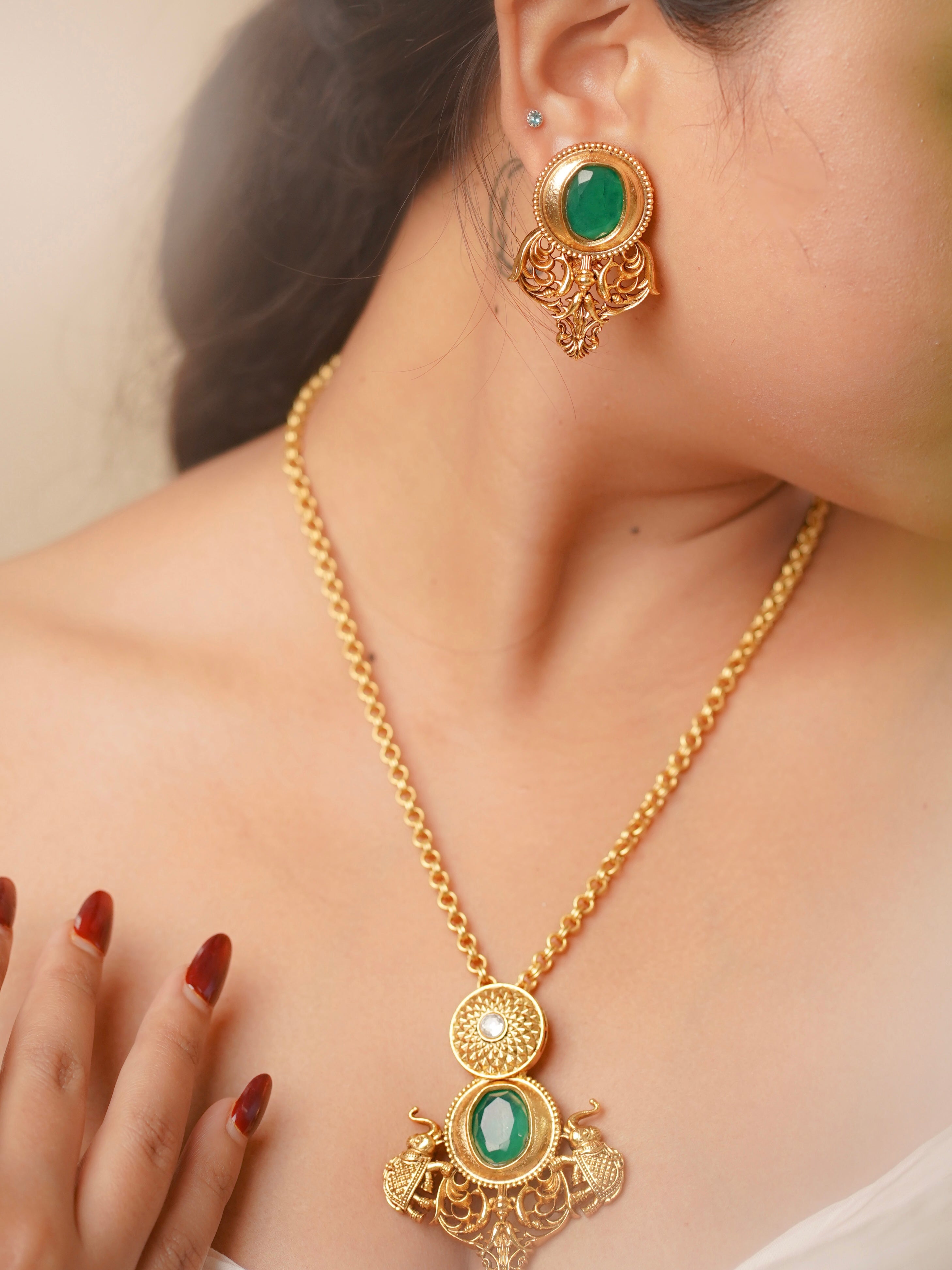 Side view of statement emerald necklace with traditional detailing and kundan-style earrings