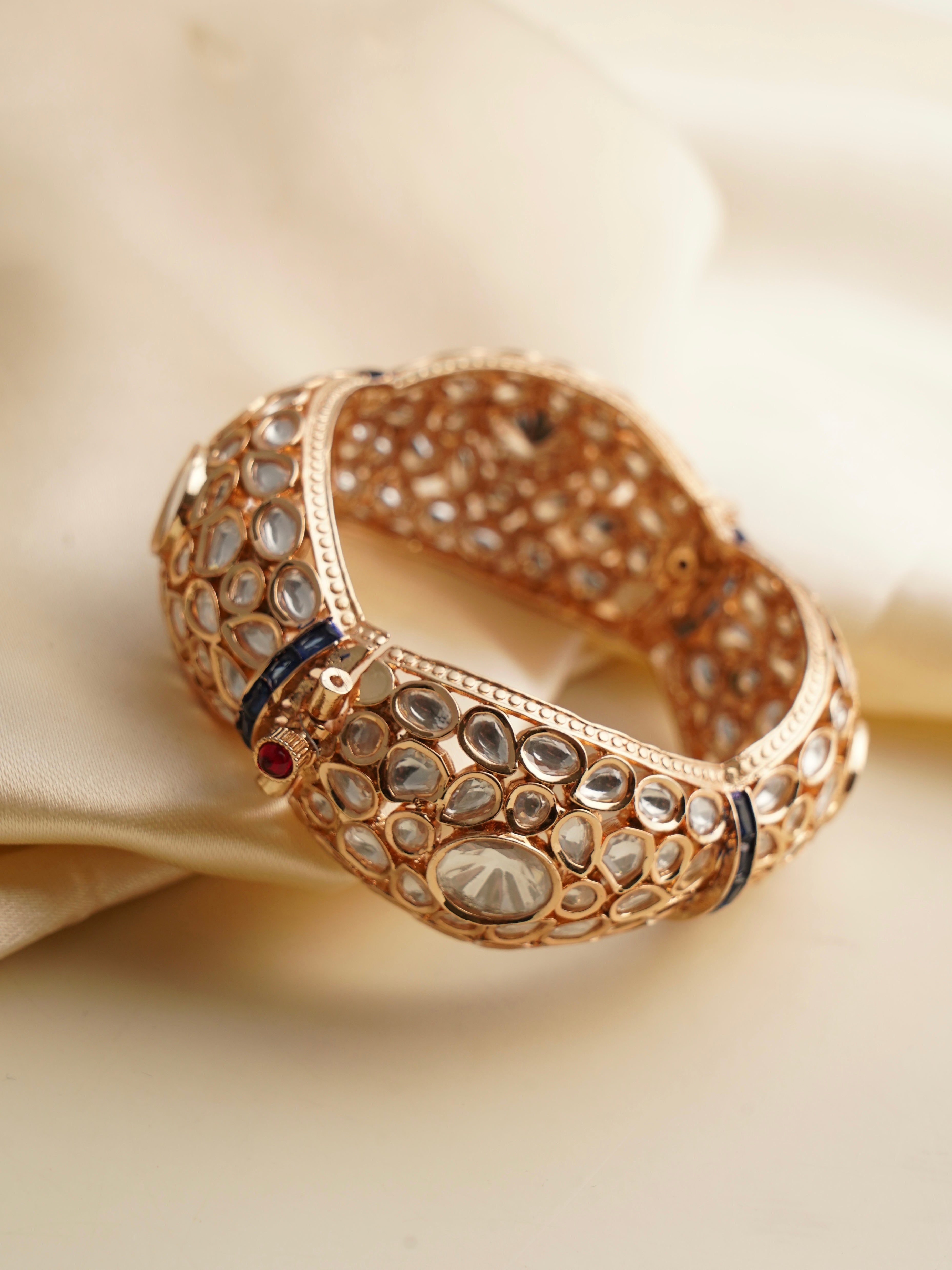 Angled view of gold kada with uncut polki stones and detailed kundan craftsmanship