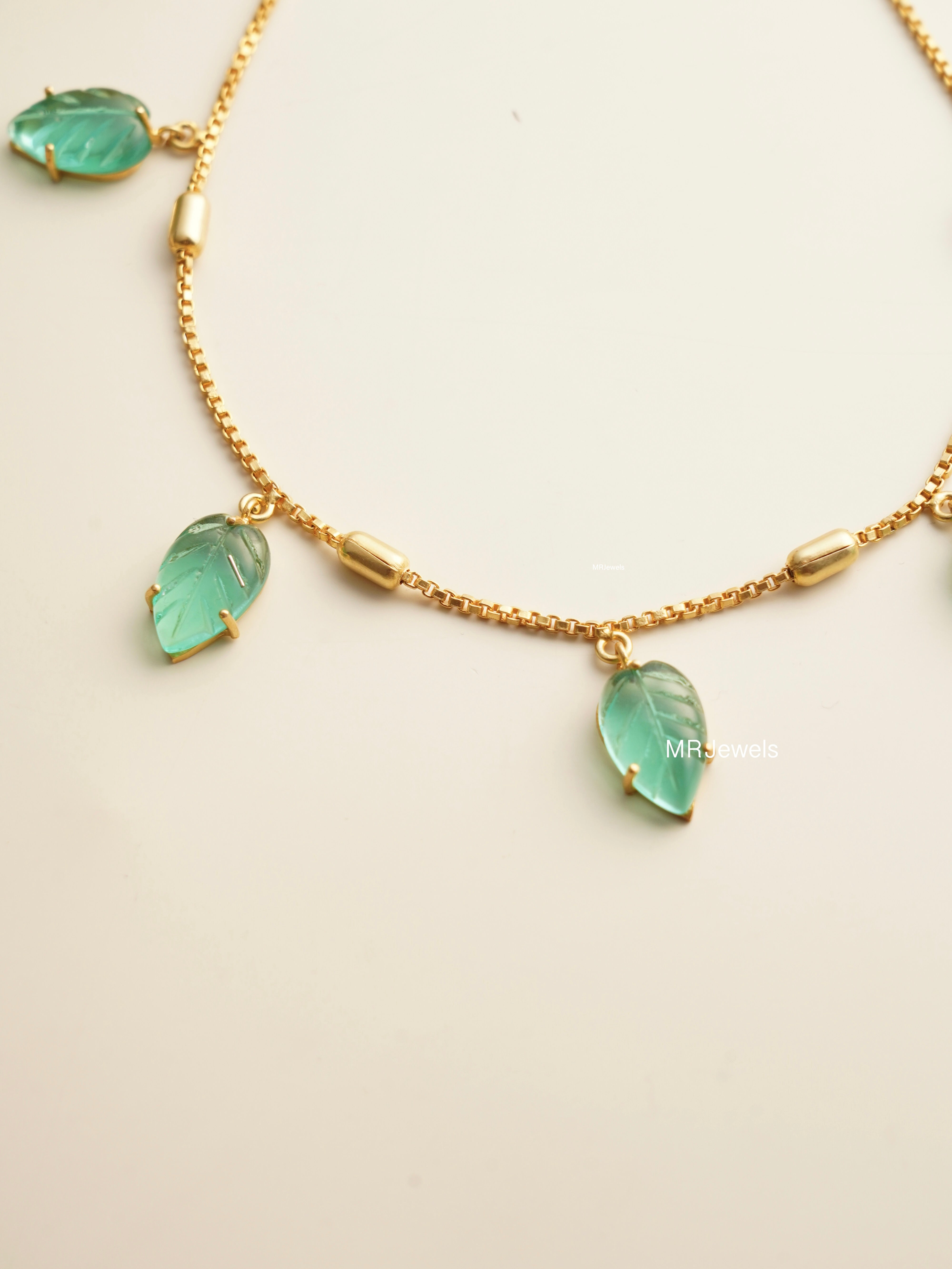 Back view of gold-plated necklace clasp and garnet charm detailing