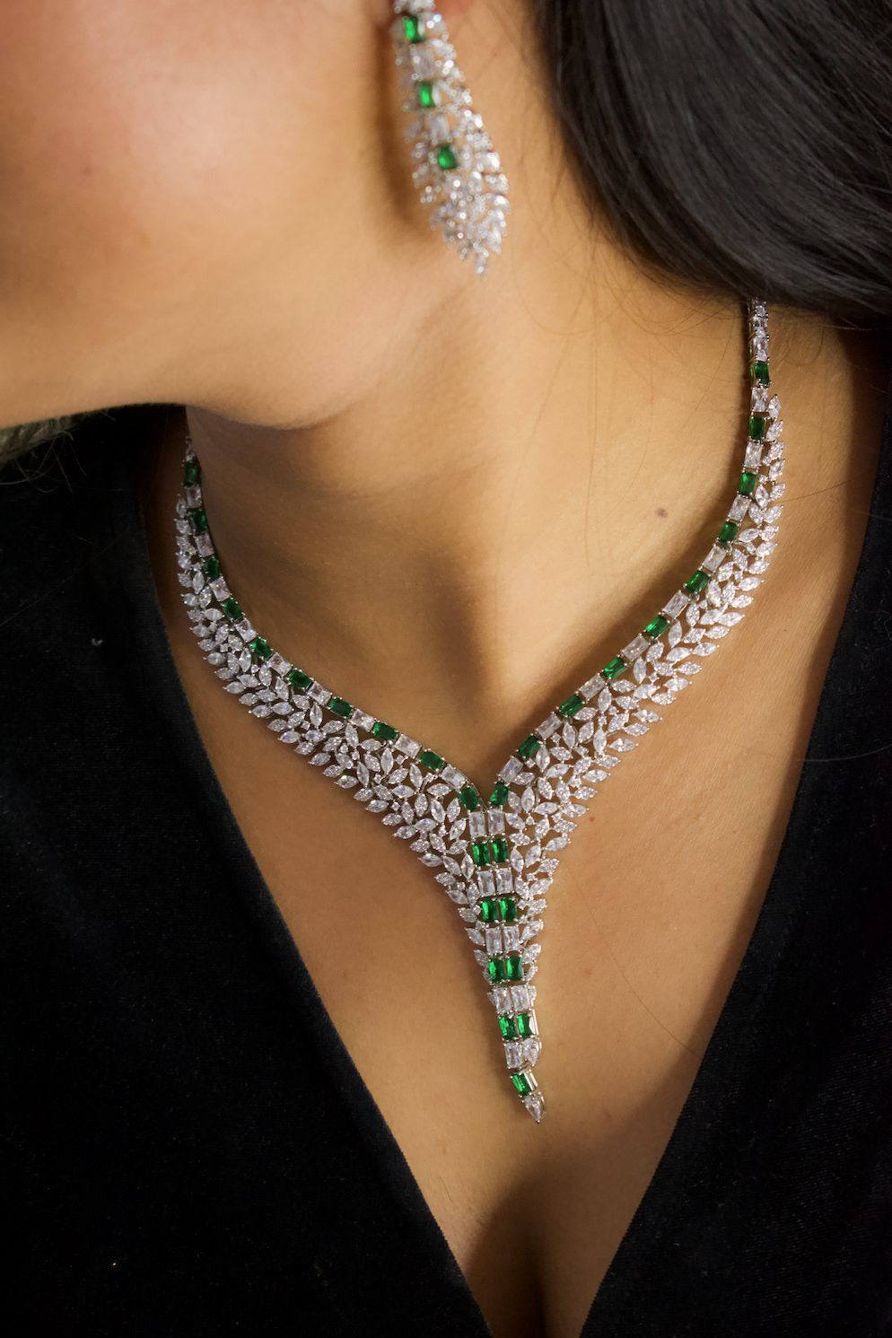 Front view of emerald and diamond necklace with intricate leaf and vine detailing