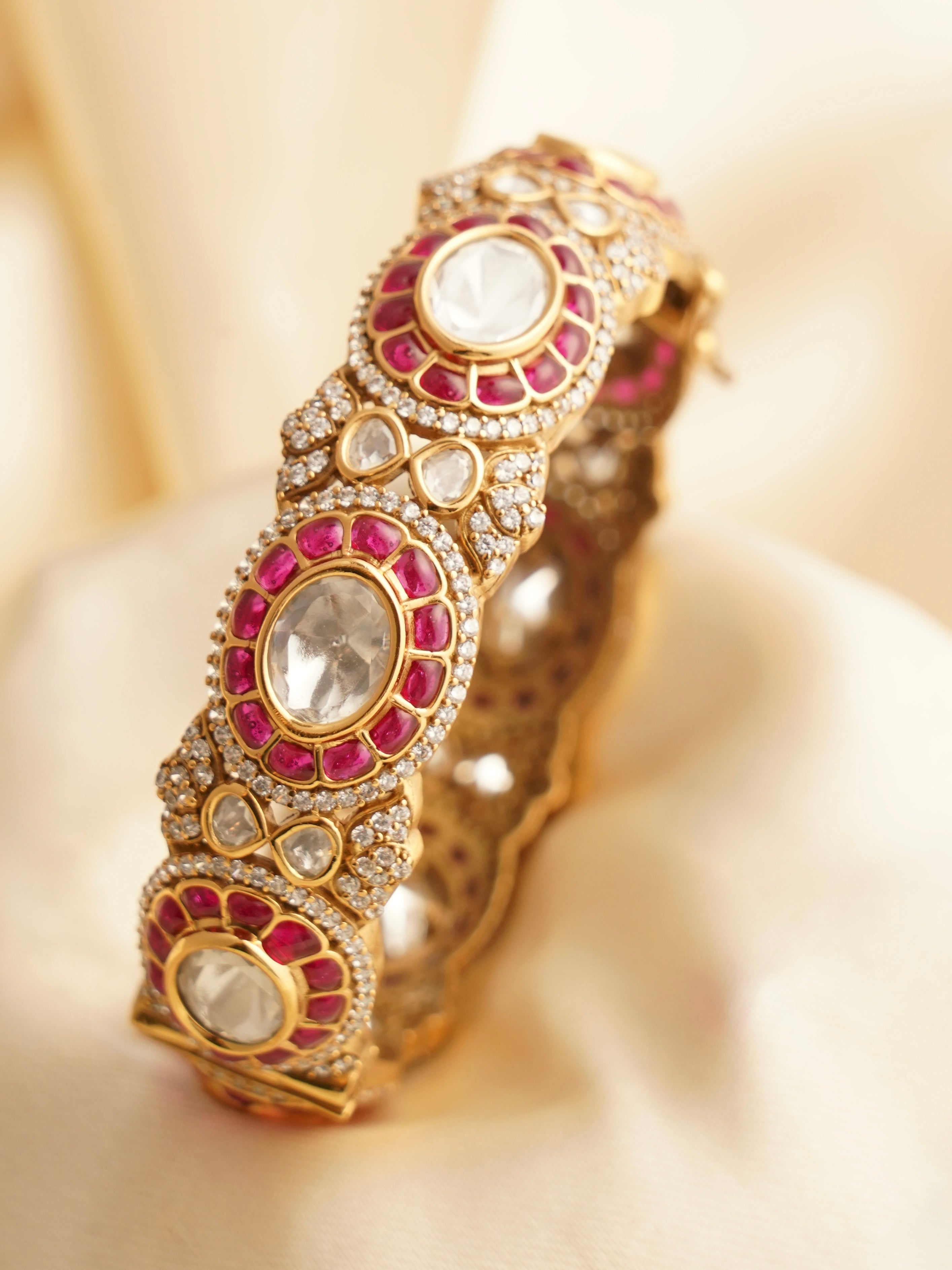 Angled shot of ruby-studded bangle highlighting stone alignment and glossy finish