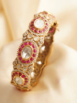 Angled shot of ruby-studded bangle highlighting stone alignment and glossy finish