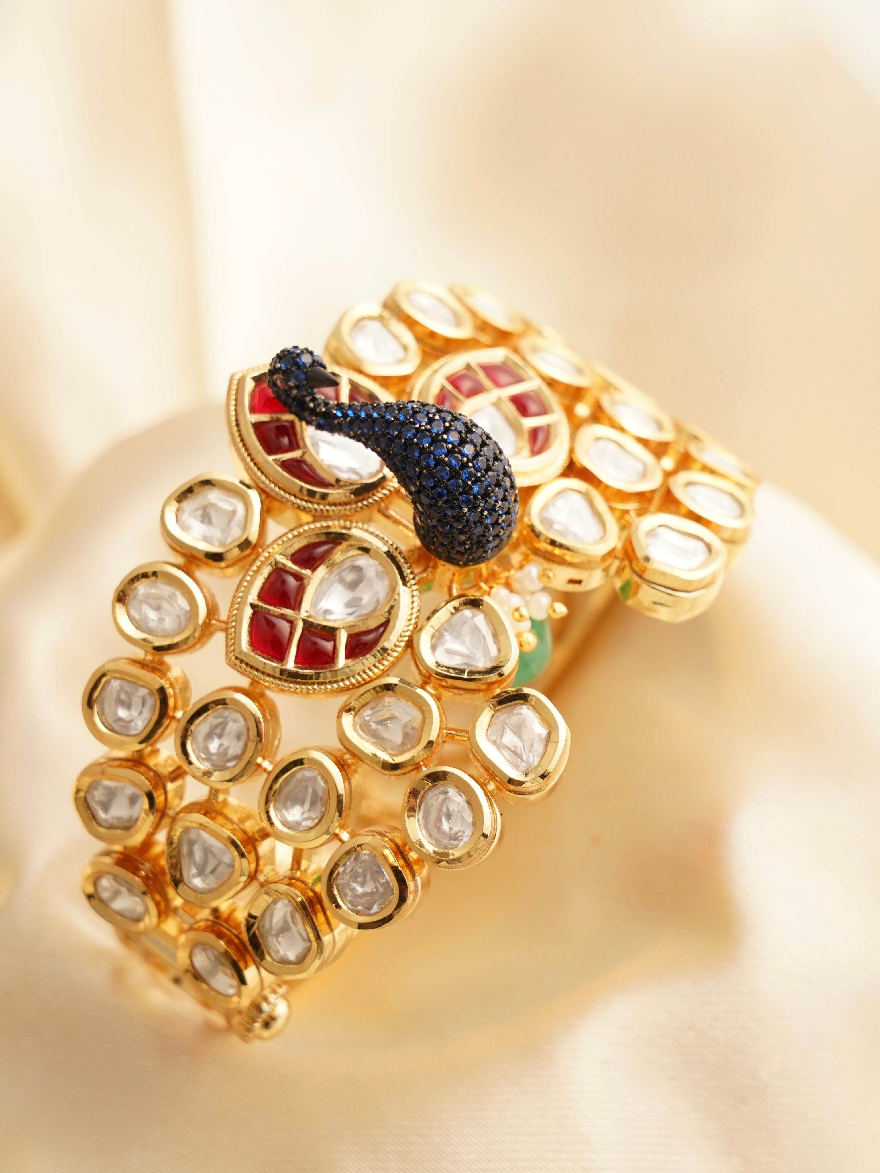 side angle of peacock bracelet featuring intricate feathers and diamond sparkle